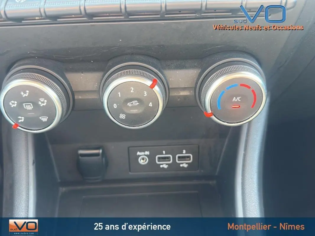 Gros plan sur les commandes de climatisation manuelle et ports USB du Renault Captur gris TCe 90 Business 2022.