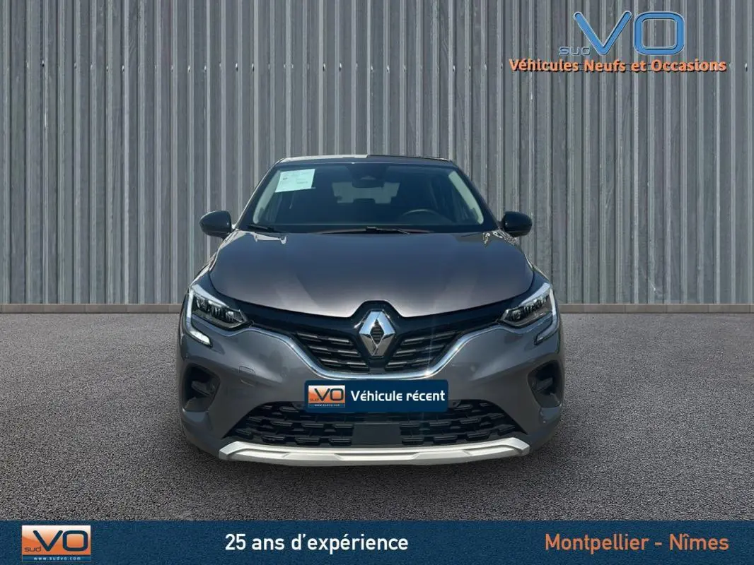 Vue frontale d'un Renault Captur TCe 90 Business gris 2022 avec calandre noire et logo Renault lumineux.