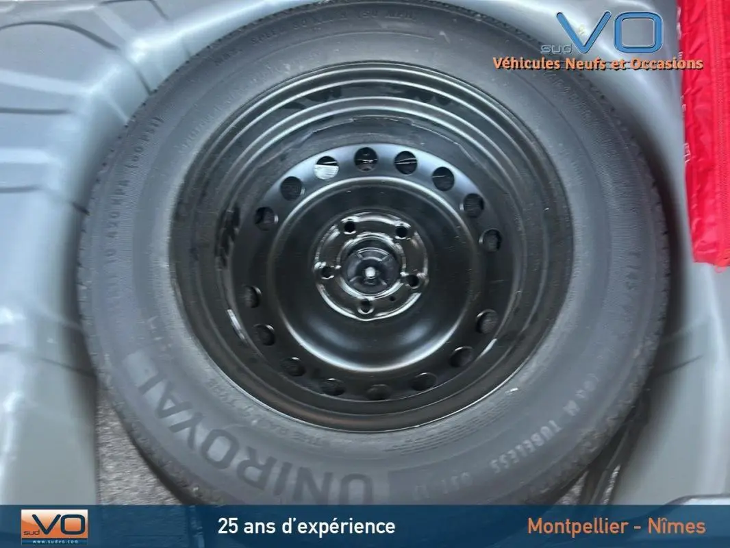 Roue de secours noire en gros plan dans le coffre d'un Renault Captur TCe 90 gris 2022.