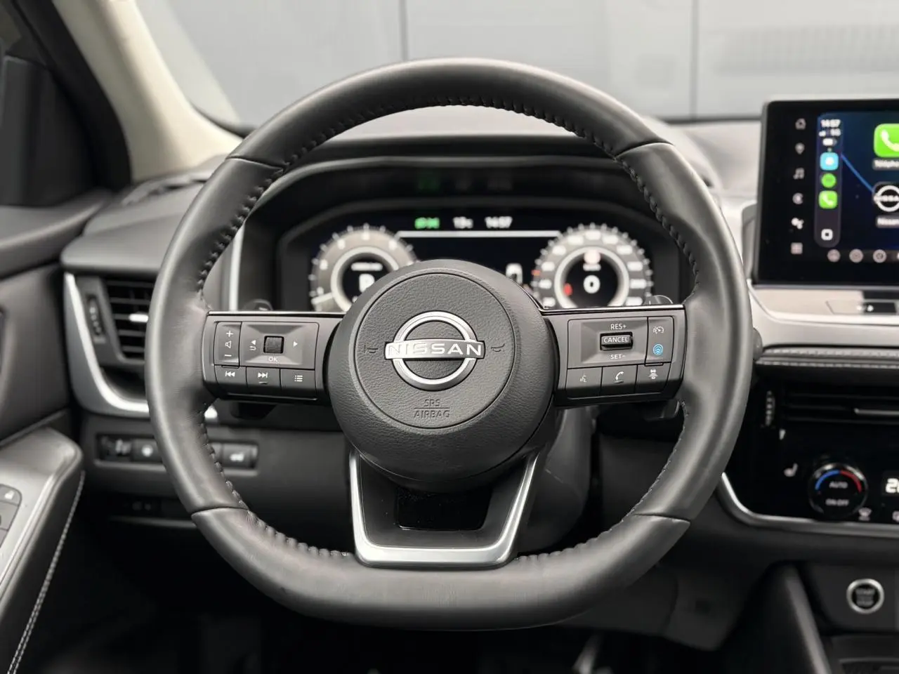 Volant cuir noir Nissan Qashqai 2024 vu de face avec commandes intégrées et tableau de bord numérique.