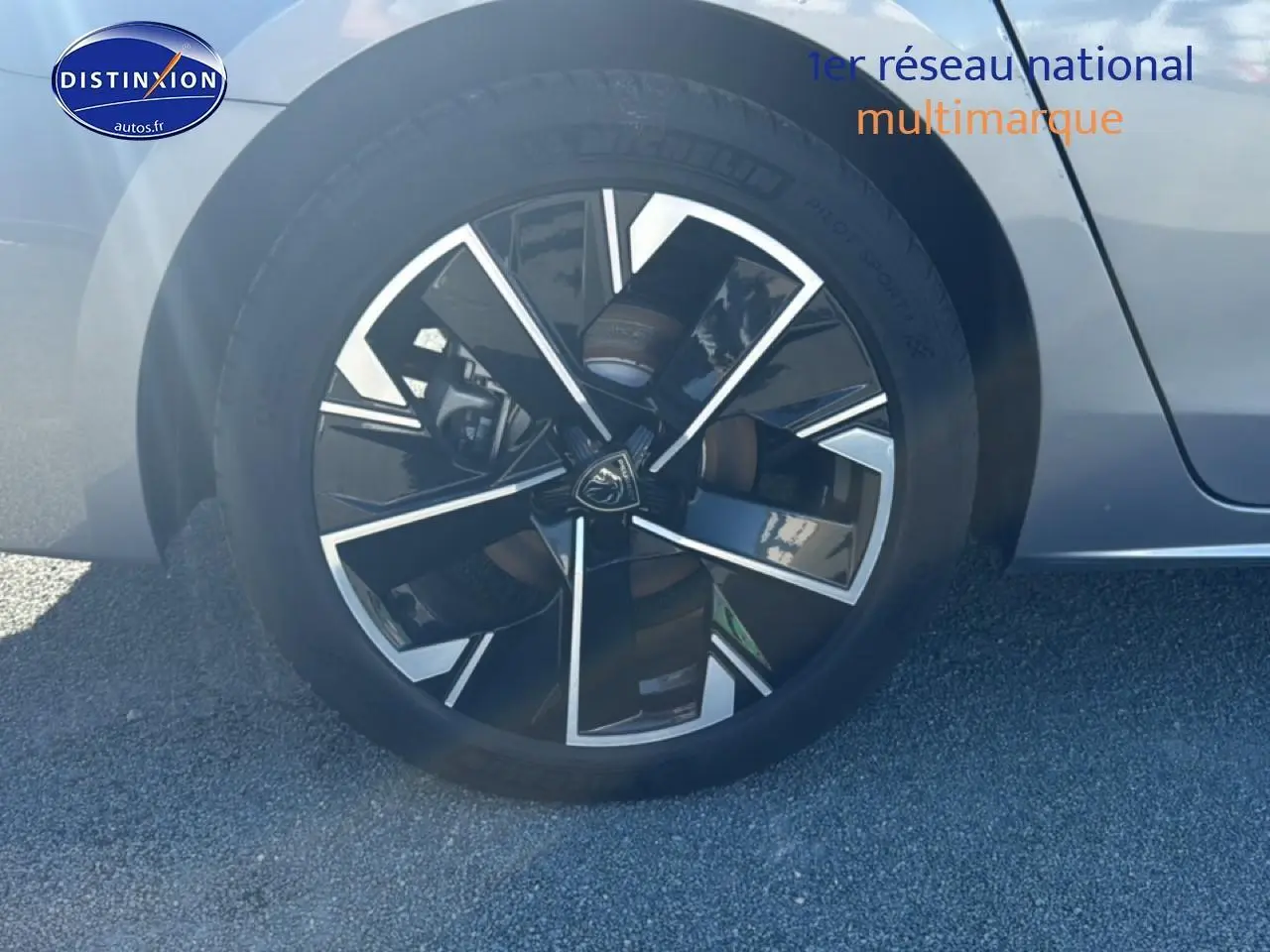 Gros plan sur la jante alu noire et argentée du côté avant gauche d'une Peugeot 508 SW gris artense.