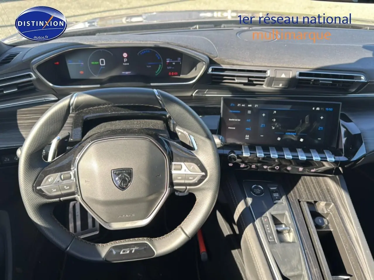 Vue intérieure centrée sur le volant cuir GT et le tableau de bord numérique de la Peugeot 508 SW Hybrid 225 gris Artense.