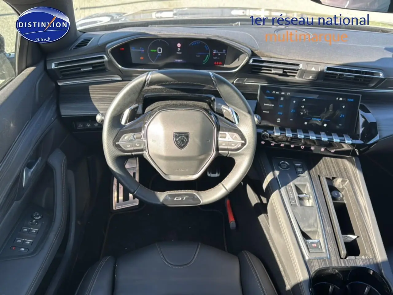 Vue intérieure avant du poste de conduite du Peugeot 508 SW Hybrid gris, avec volant GT et écran tactile large.