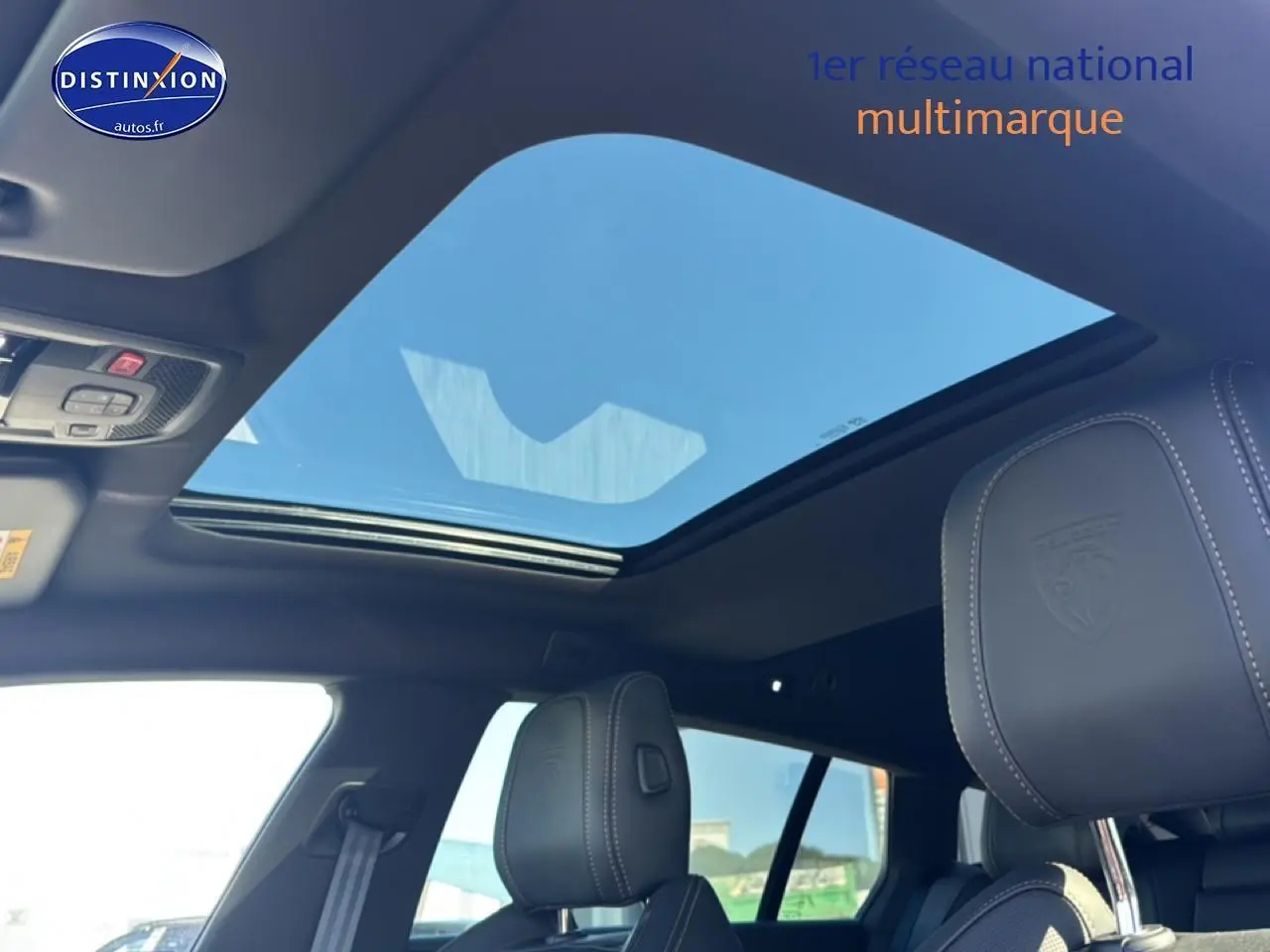 Vue intérieure du toit ouvrant panoramique et des appuis-tête en cuir embossé du Peugeot 508 SW Hybrid 225 gris artense.