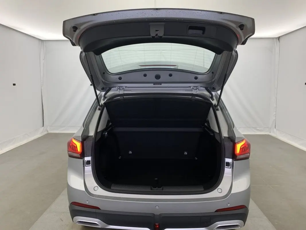 Vue arrière du MG ZS 1.5 L Hybrid+ 2026 en Cosmic Silver avec coffre ouvert et feux arrière allumés.