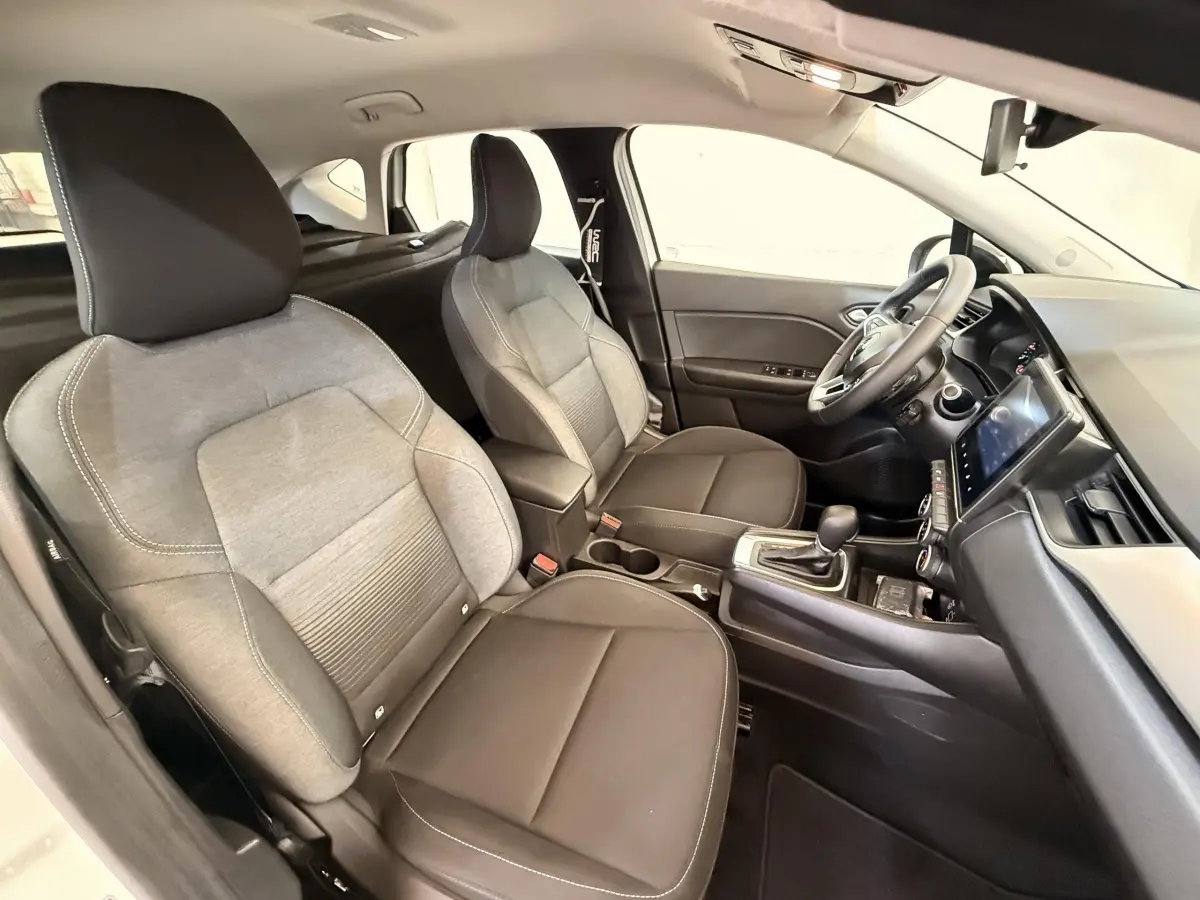 Vue intérieure avant droite du Renault Captur Business 2021, sièges bi-matière gris et noir avec tableau de bord moderne.