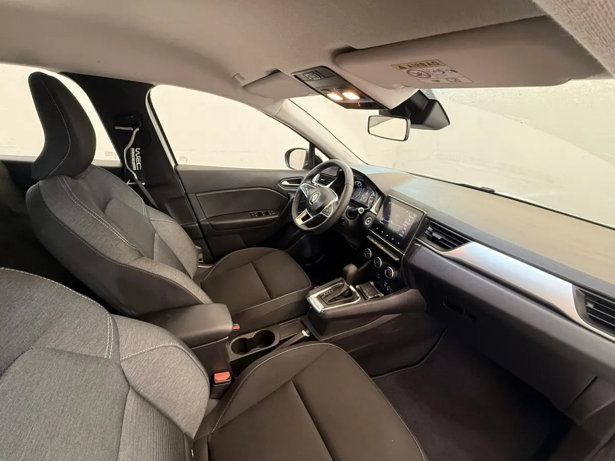 Vue intérieure côté conducteur du Renault Captur Business 2021, montrant sièges tissu gris et tableau de bord moderne.