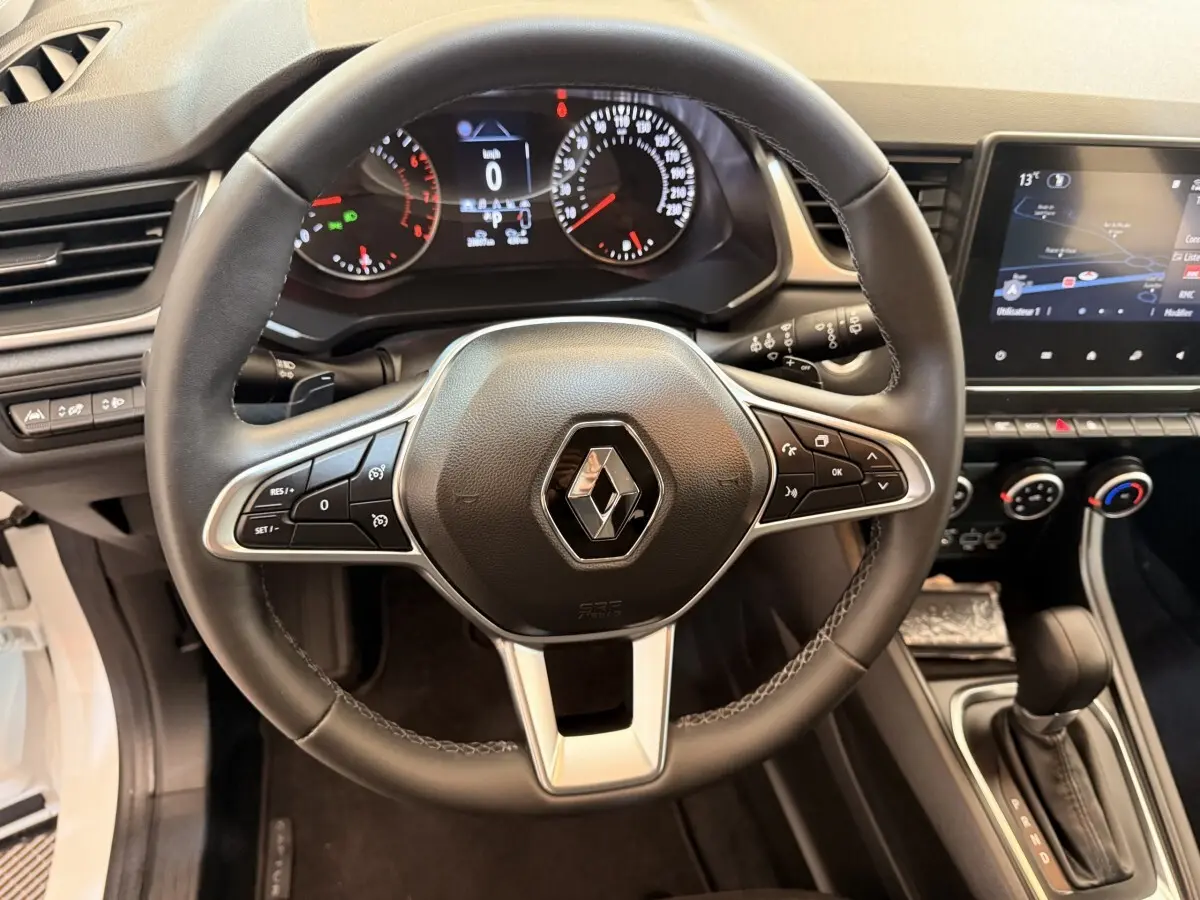 Vue intérieure centrée sur le volant cuir noir du Renault Captur 2021 avec tableau de bord et écran tactile visible.
