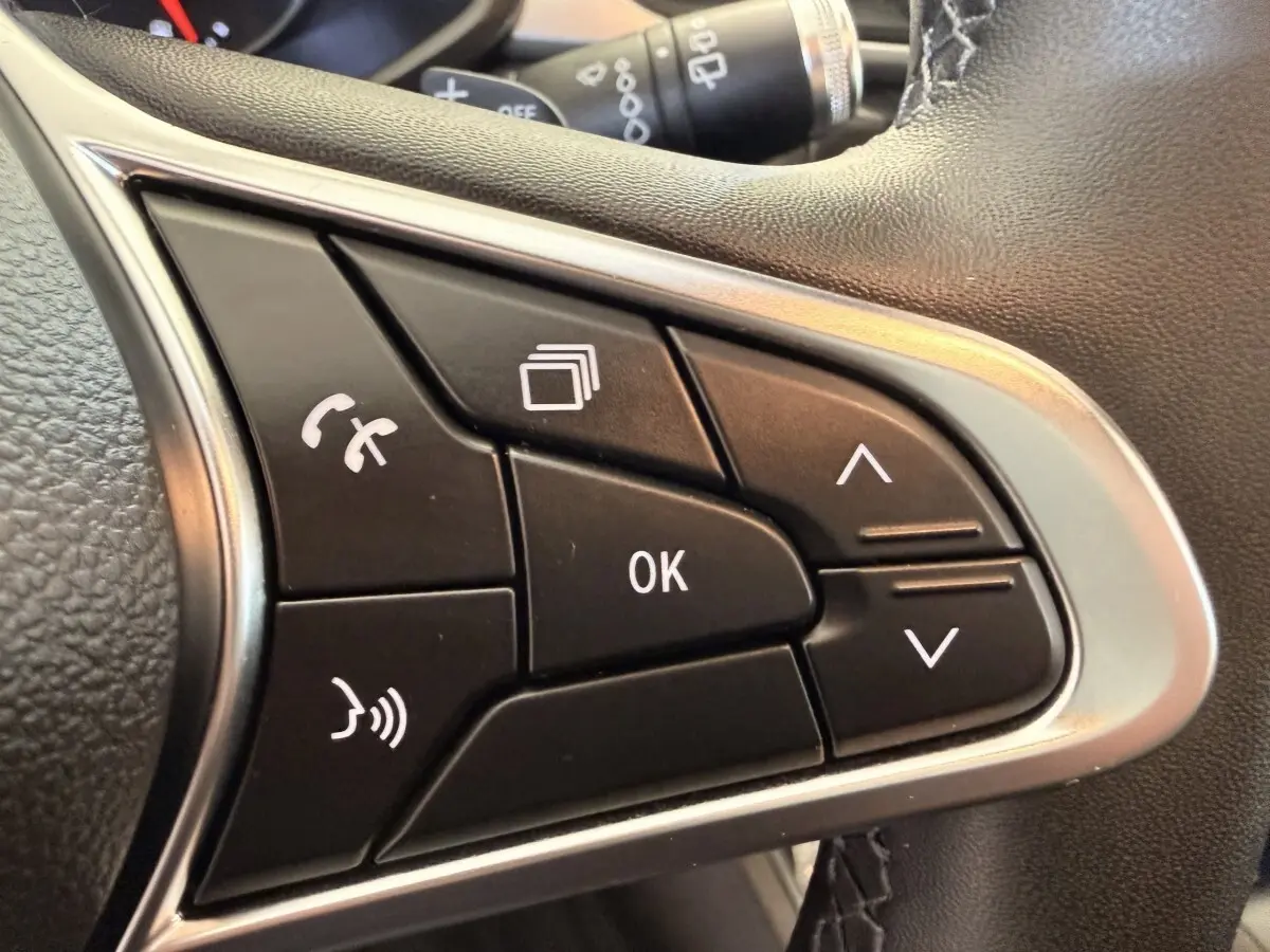 Gros plan sur les commandes noires multifonctions du volant côté droit du Renault Captur blanc, version Business 2021.