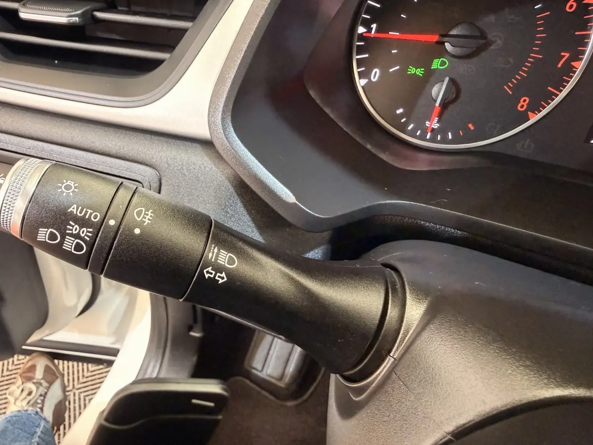 Gros plan sur la commande des phares et clignotants du tableau de bord d'un Renault Captur blanc, version 2021.