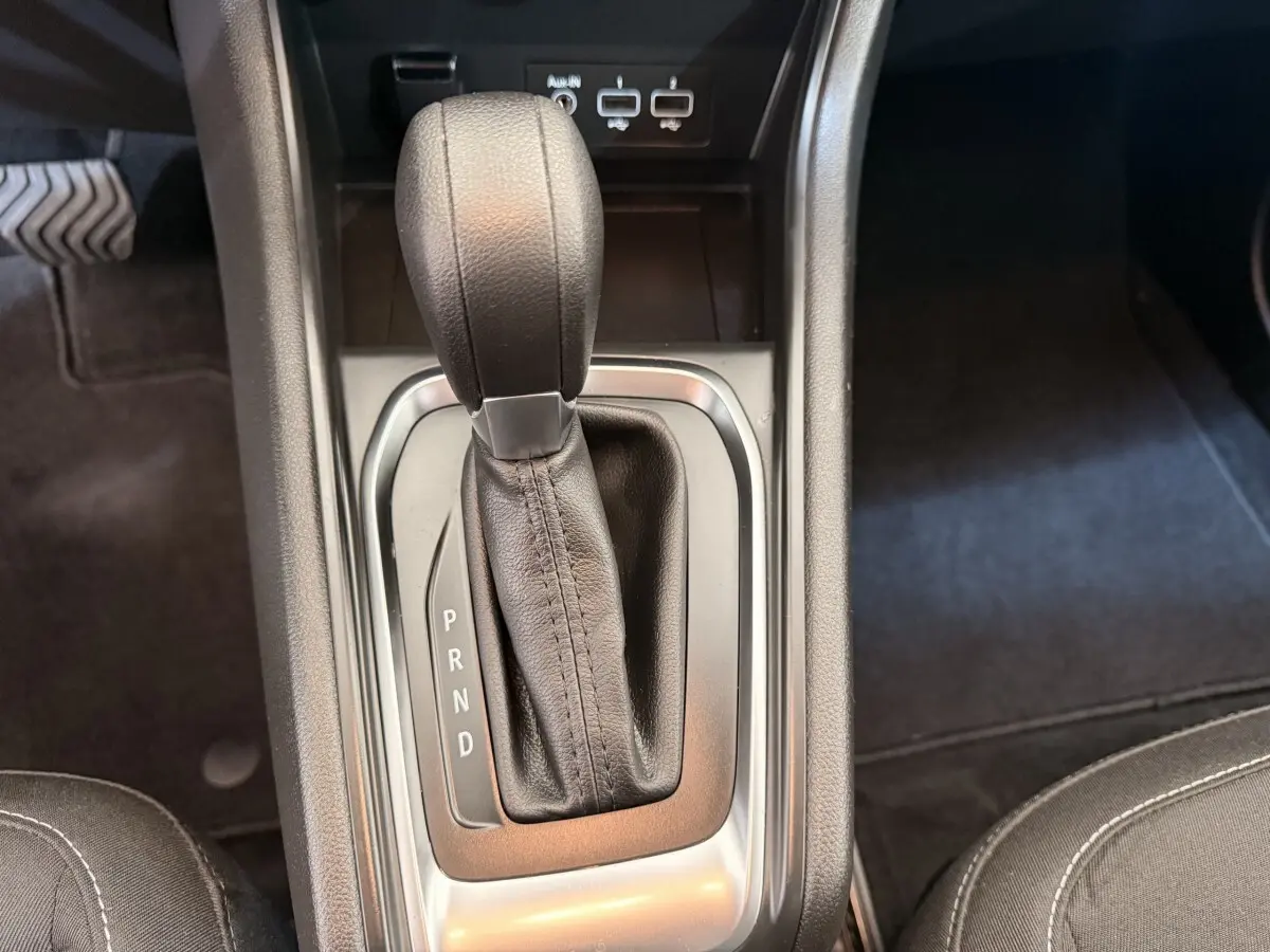 Gros plan sur le levier de vitesses automatique noir du Renault Captur Business blanc, avec ports USB visibles en arrière-plan.