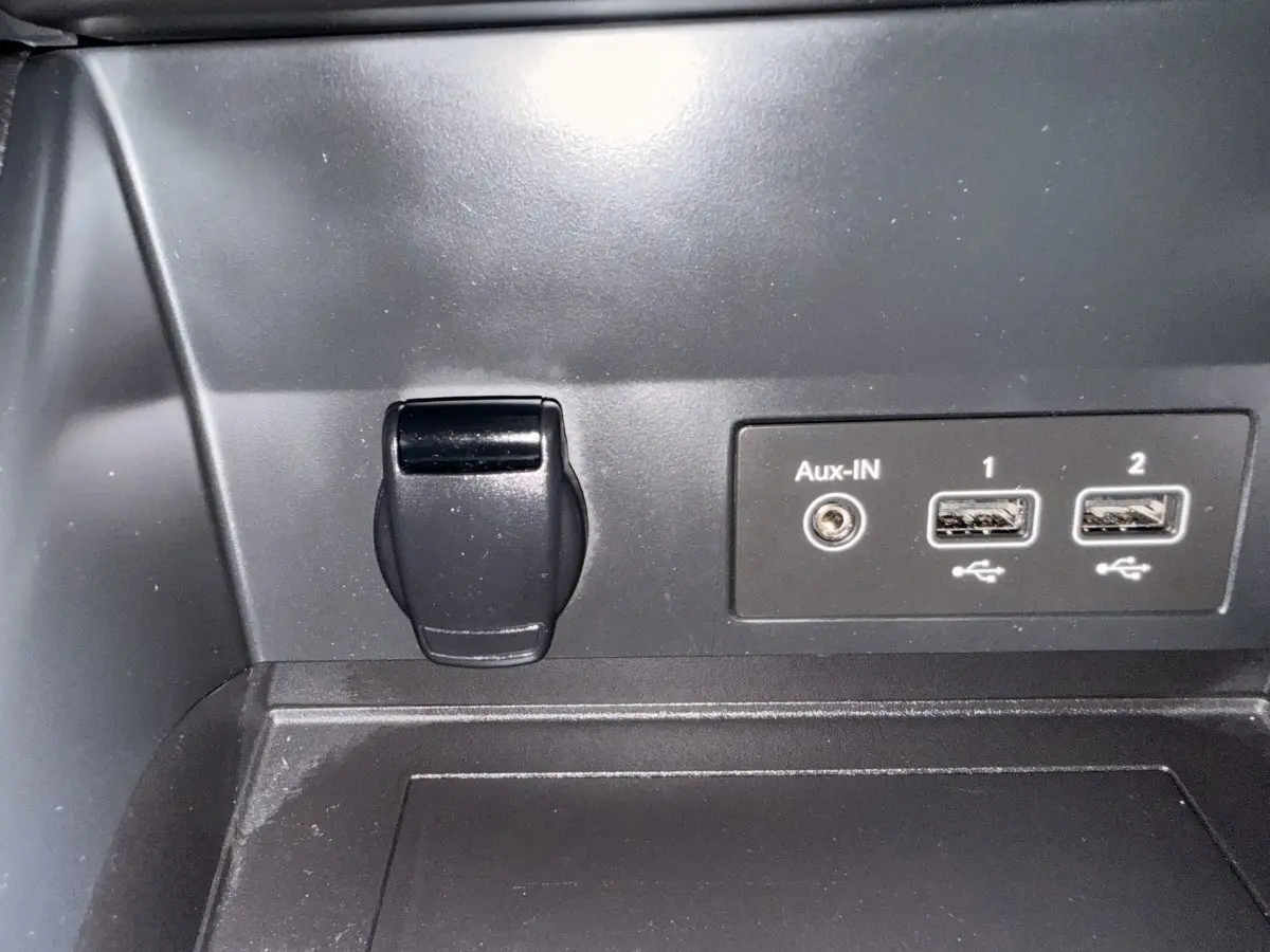 Prise auxiliaire et deux ports USB noirs dans l’habitacle du Renault Captur Business TCe 140 blanc, vue rapprochée.