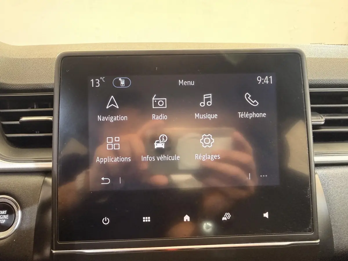Écran tactile central du tableau de bord du Renault Captur blanc, affichant le menu principal avec options multimédia.