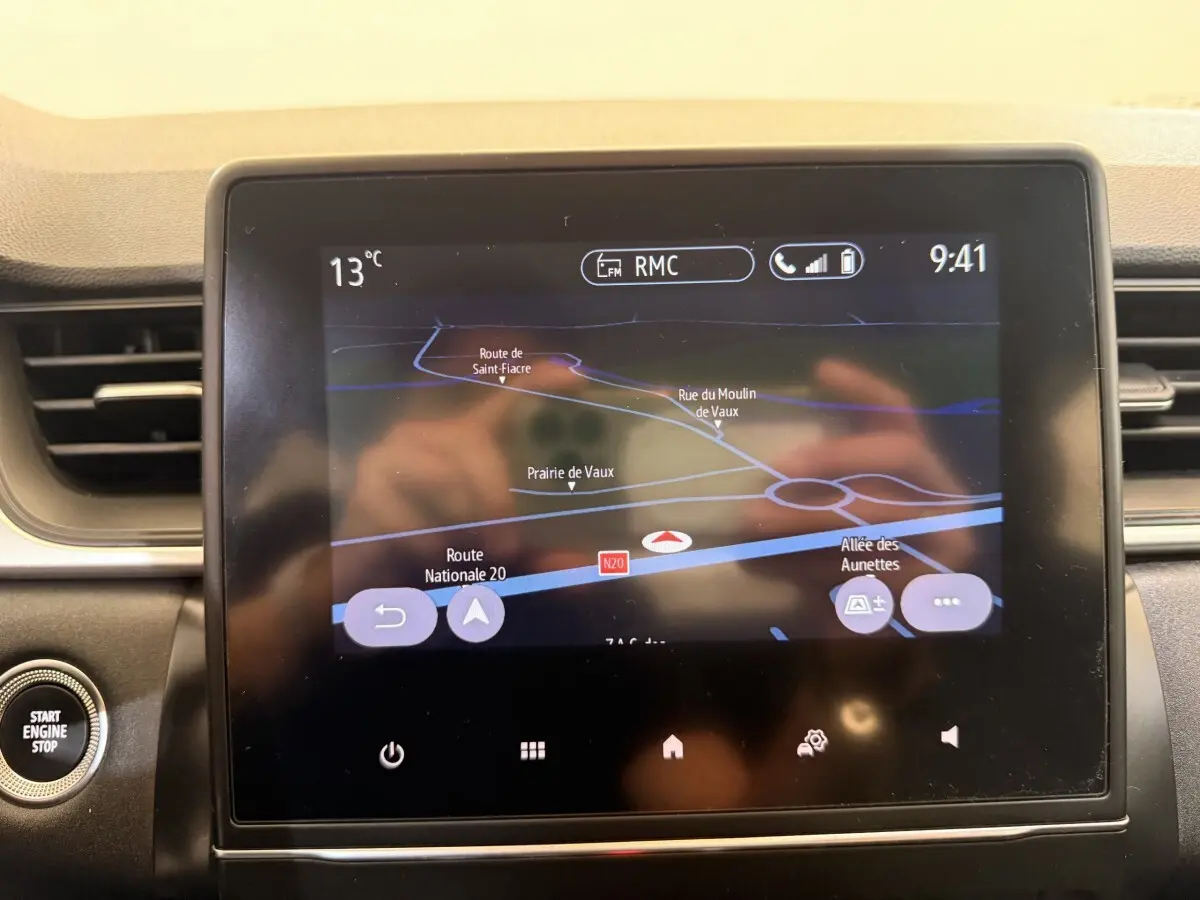 Écran tactile central du tableau de bord du Renault Captur blanc, affichant la navigation GPS en intérieur.