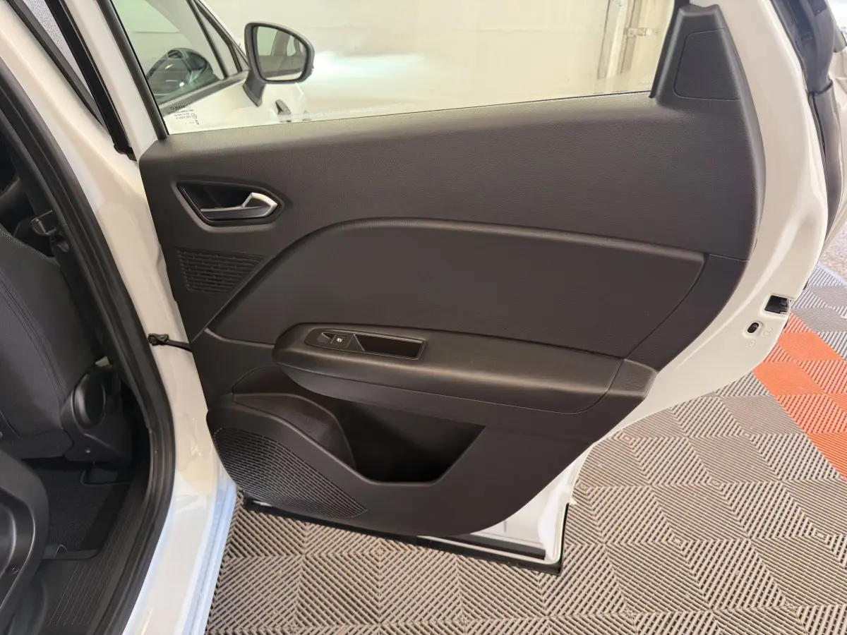 Vue intérieure de la porte arrière droite du Renault Captur blanc, avec panneau noir et commande de vitre électrique.