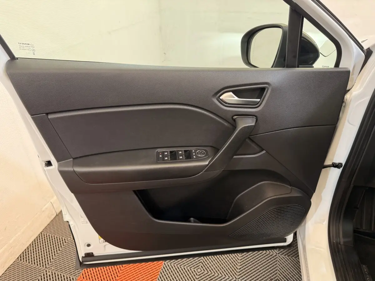 Vue intérieure de la porte avant gauche noire du Renault Captur blanc 2021, avec commandes de vitres et rétroviseurs.