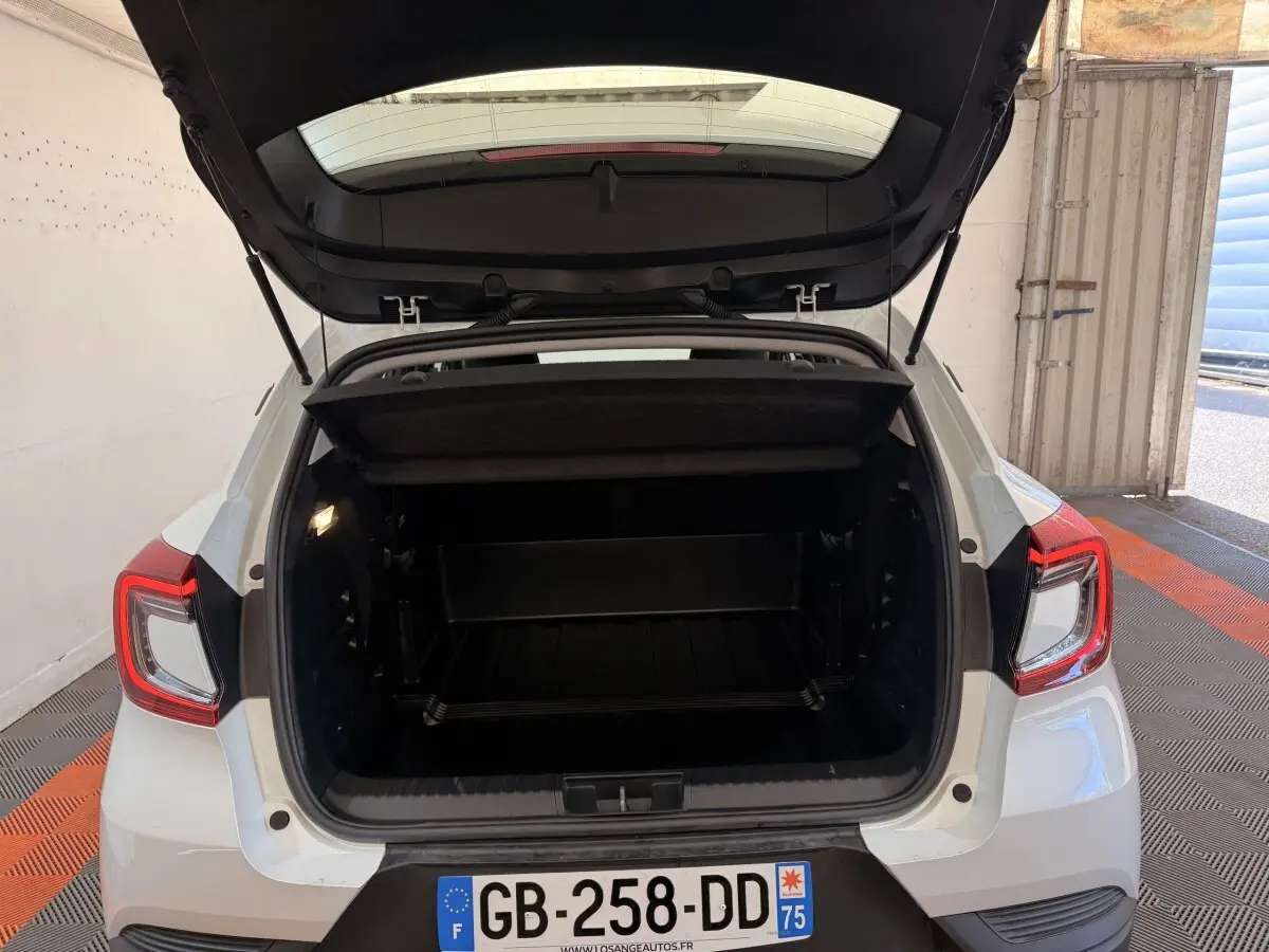 Vue arrière du coffre ouvert d'un Renault Captur blanc 2021, montrant l'espace de chargement intérieur.