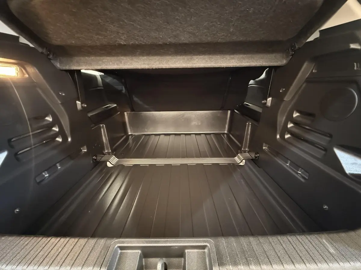 Coffre ouvert du Renault Captur Business blanc, vue intérieure montrant l'espace de chargement et le plancher plat.
