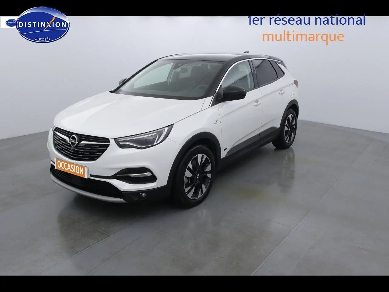 Opel Grandland X blanc nacré vue 3/4 avant droit avec toit noir et jantes alliage bicolores.