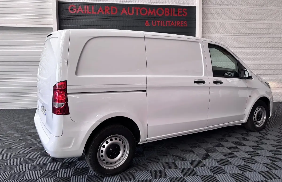 Vue 3/4 arrière droite d’un utilitaire Mercedes Vito blanc 111 CDI Compact avec hayon et 2 portes latérales.