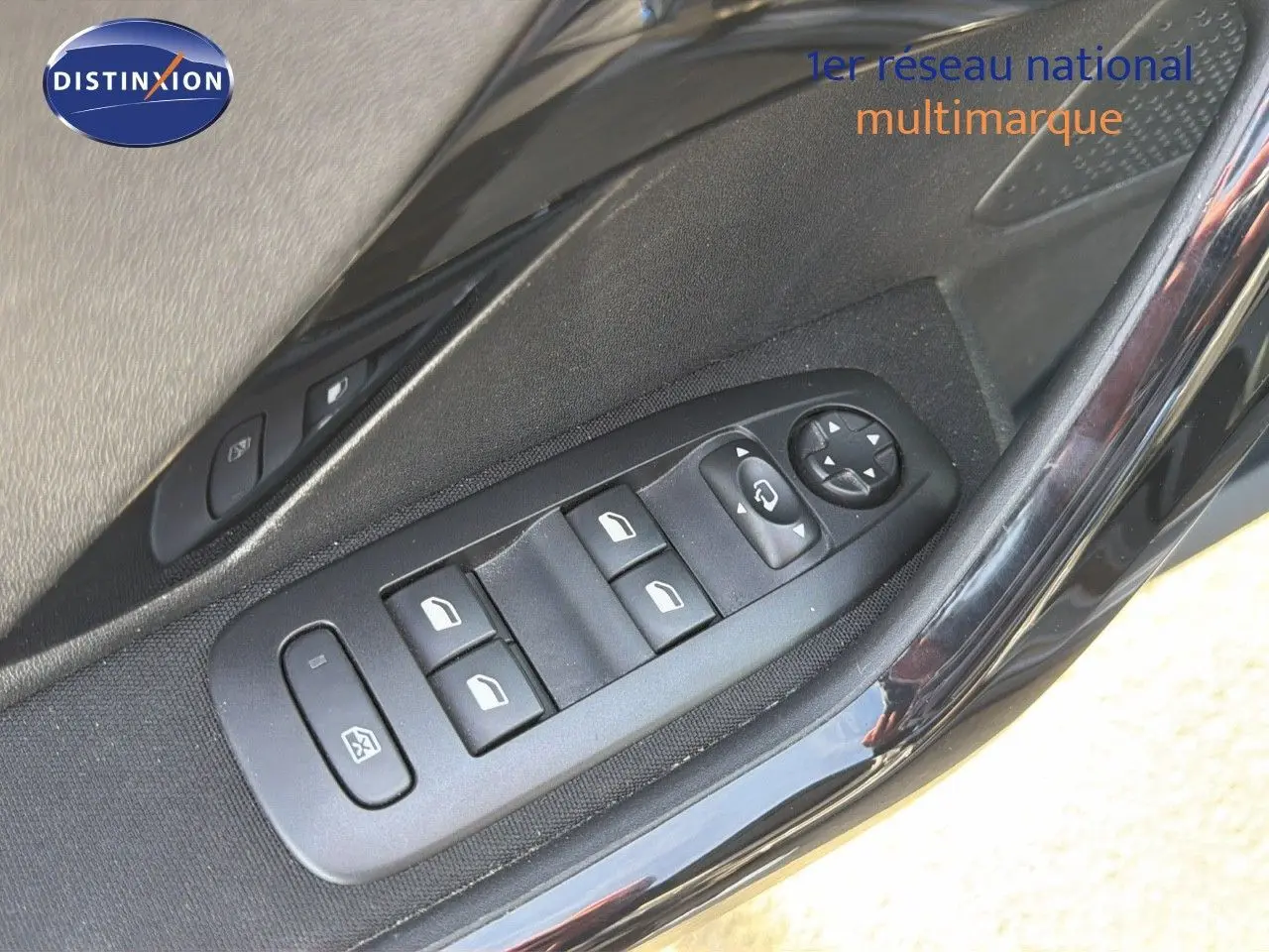 Gros plan sur les commandes des vitres électriques côté gauche d'une Peugeot 2008 gris platinium de 2019.