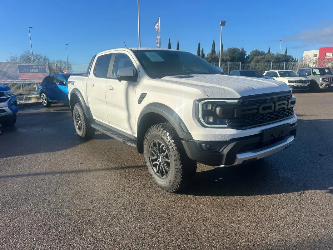 Ford Ranger Raptor blanc en 3/4 avant droit avec calandre noire et jantes alliage 17 pouces tout-terrain.
