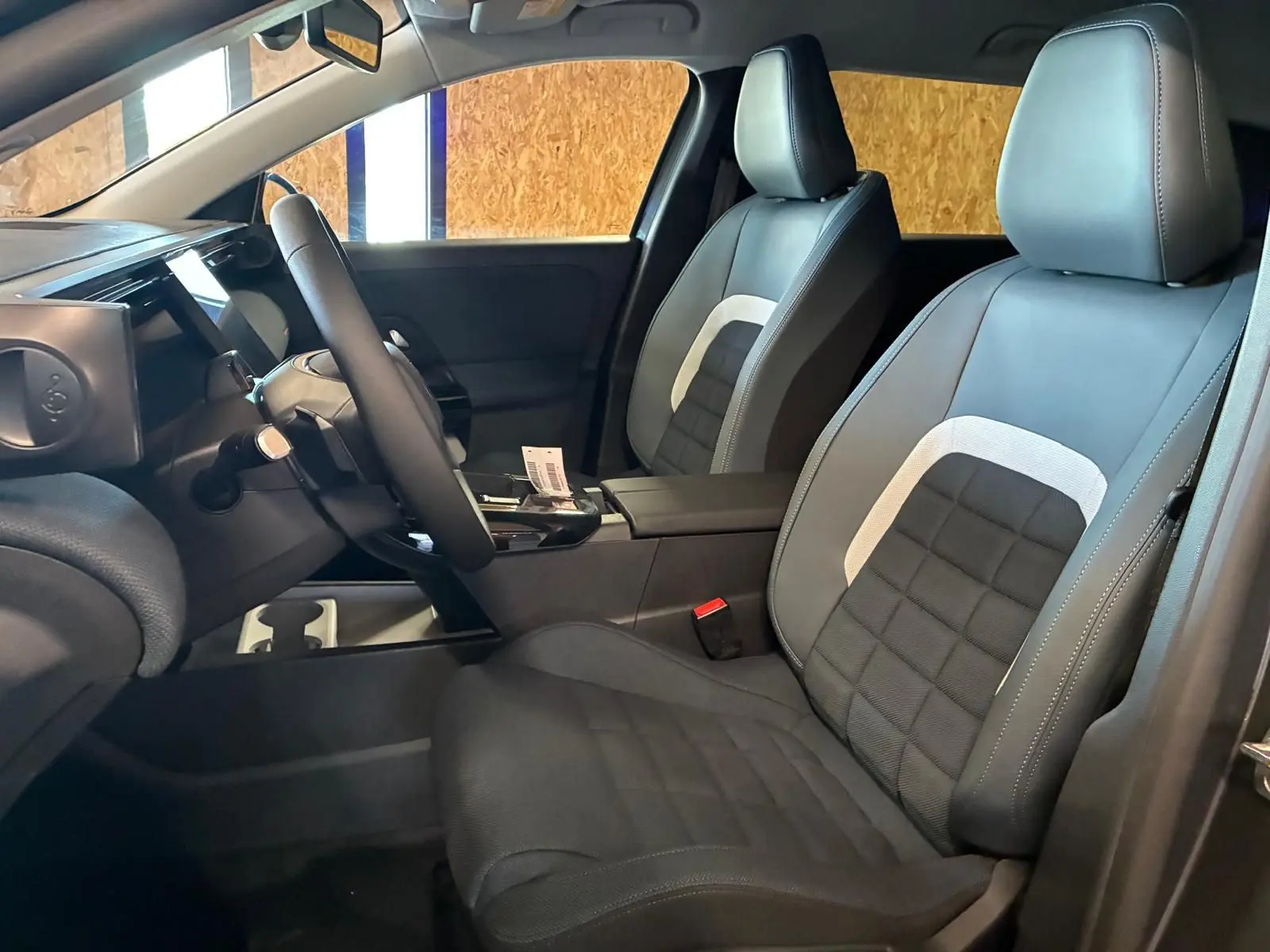 Vue intérieure côté conducteur du Citroën C5 Aircross 1.2 hybride 2026, sièges tissu noir avec inserts gris clair.