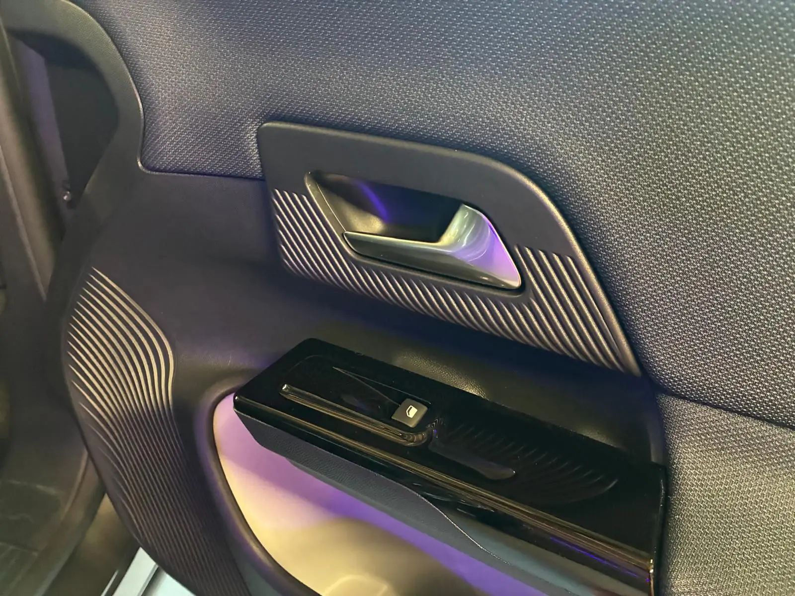 Détail de la porte intérieure côté droit du Citroën C5 Aircross gris, avec poignée argentée et commande de fenêtre noire.