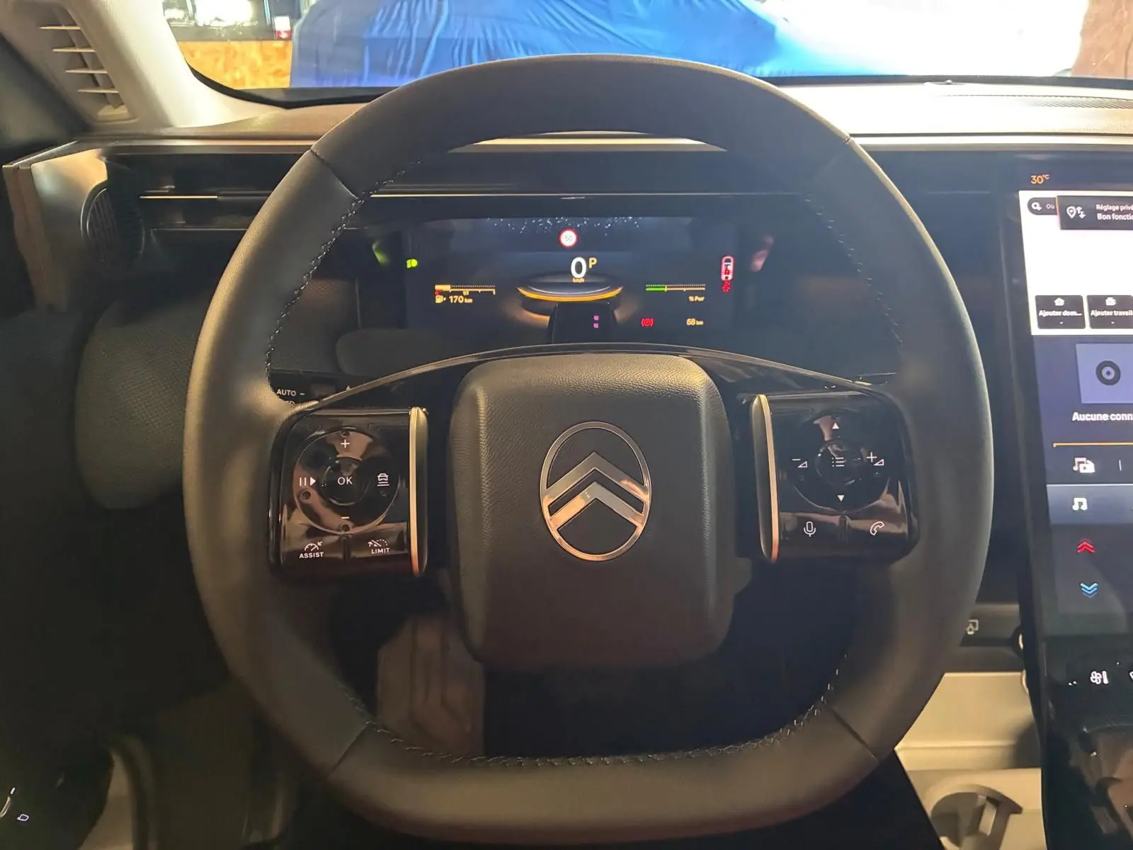 Vue rapprochée du volant noir du Citroën C5 Aircross 1.2 Hybride 2026 avec tableau de bord numérique et écran tactile.