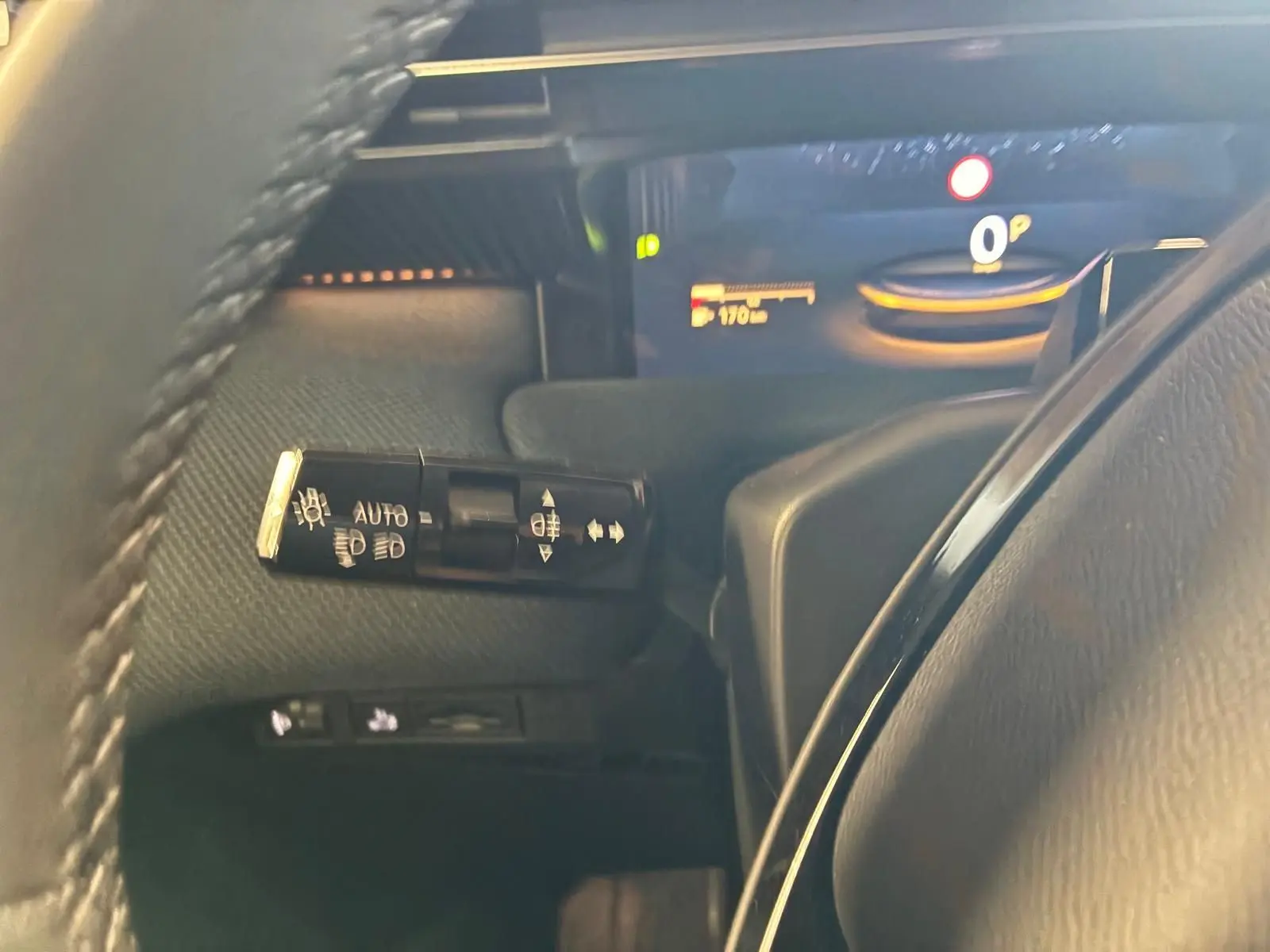 Gros plan sur la commande des phares à gauche du volant dans l’habitacle noir du Citroën C5 Aircross gris 2026.