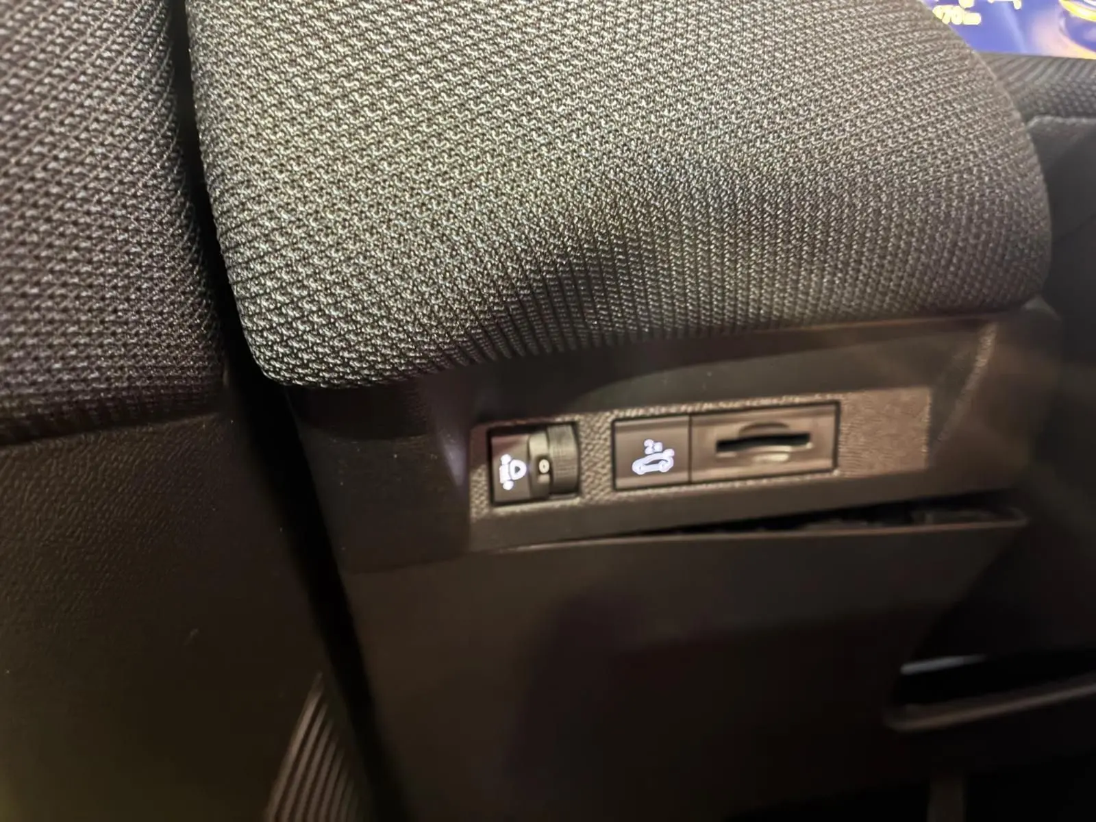 Détail des commandes sous le siège avant d’un Citroën C5 Aircross gris, version hybride 2026.