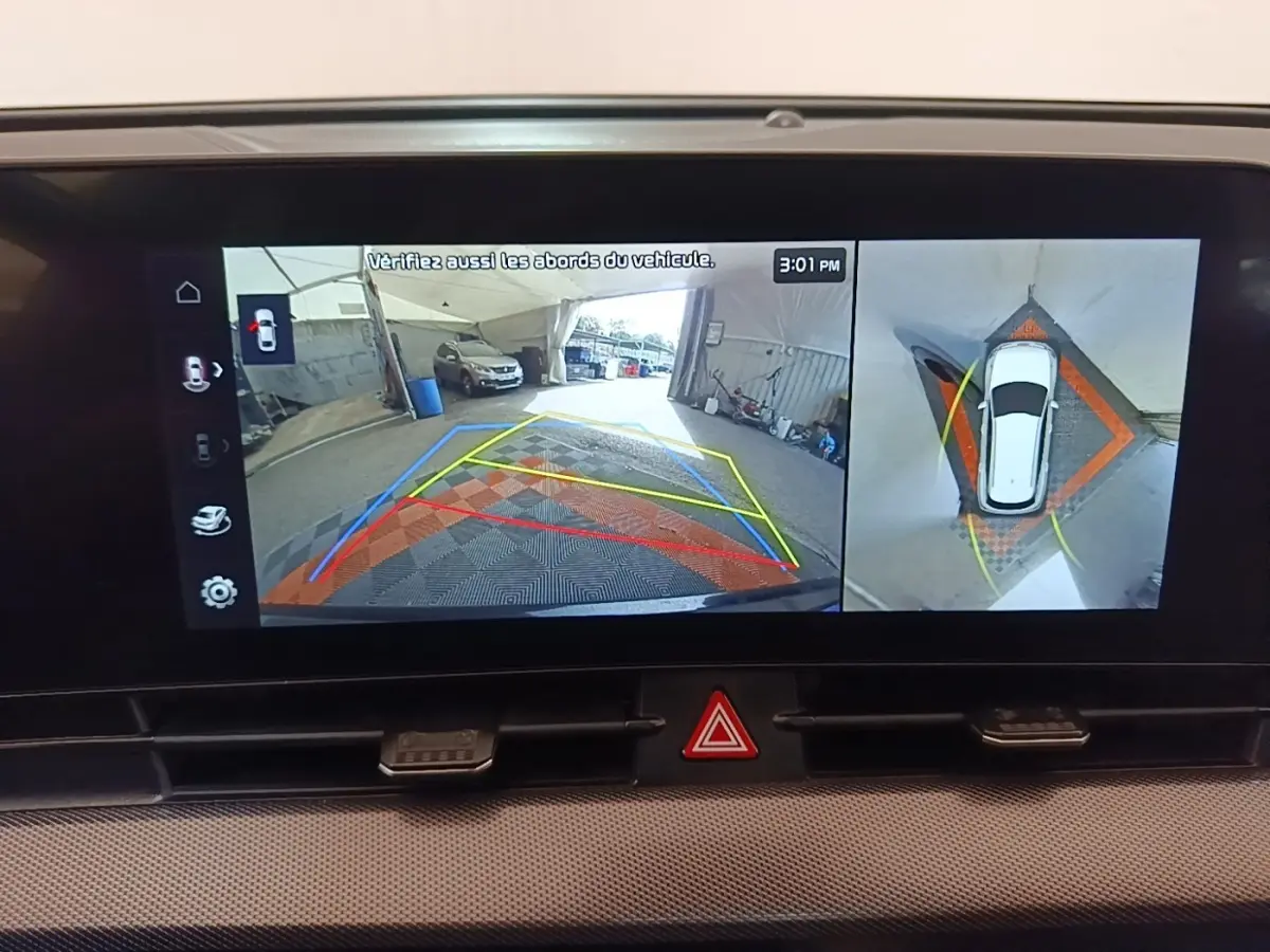 Affichage écran tactile intérieur montrant la caméra de recul et vue à 360° du Kia Sportage gris clair 2022 en stationnement.