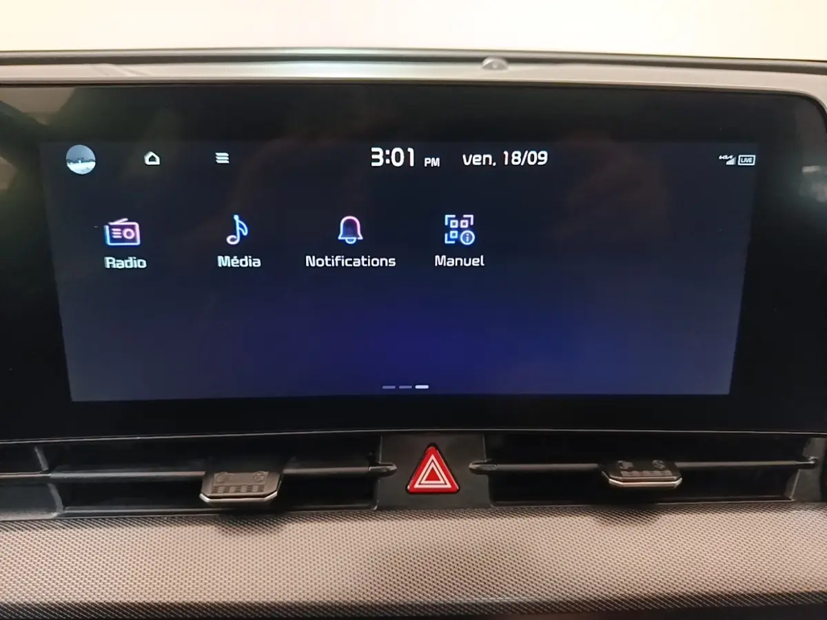 Écran tactile central du tableau de bord du Kia Sportage gris clair, affichant les menus Radio, Média, Notifications et Manuel.