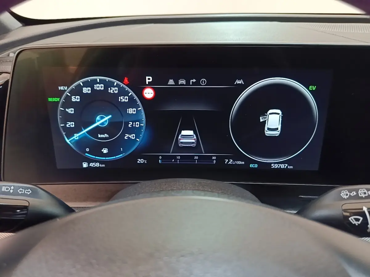 Affichage numérique du tableau de bord du Kia Sportage hybride rechargeable, vue frontale centrée sur l'écran multifonctions.