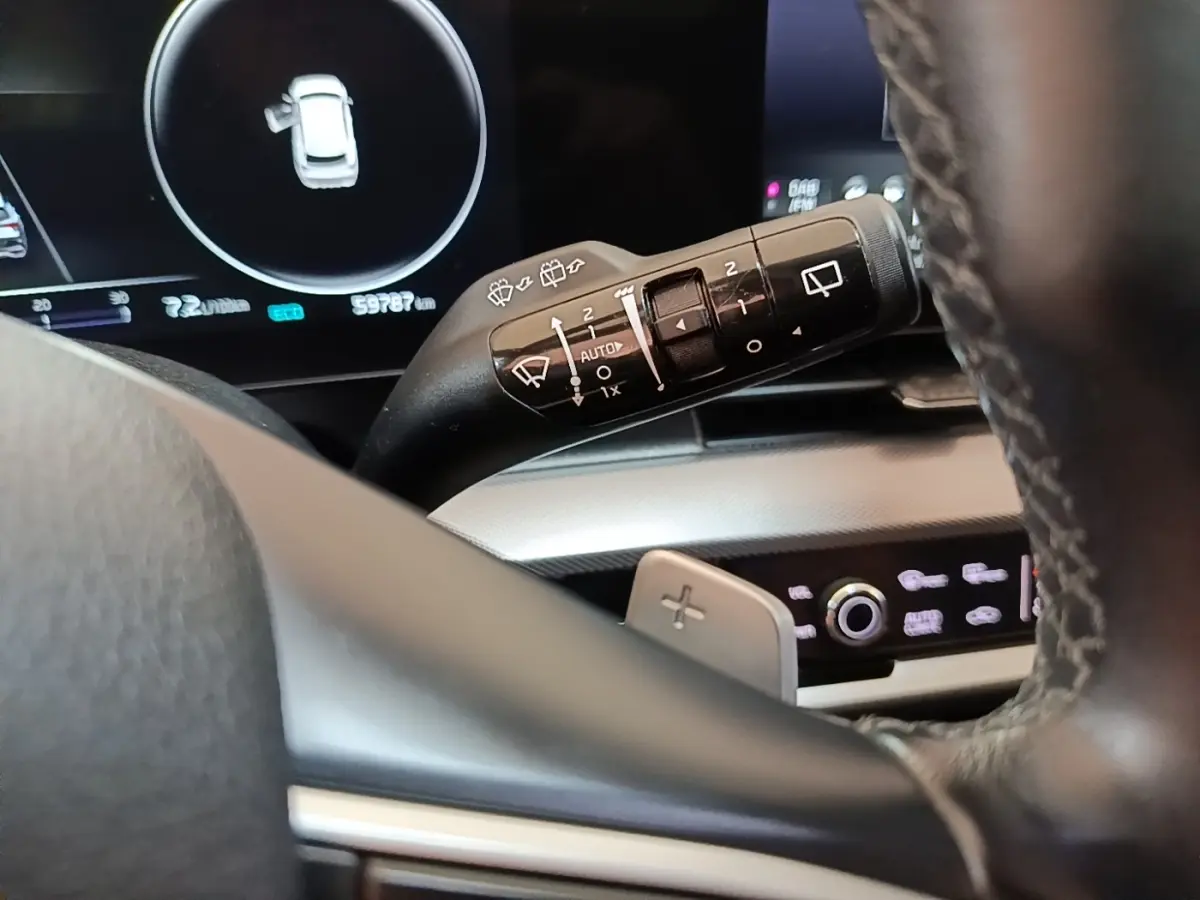 Gros plan sur la manette d’essuie-glace côté droit du volant dans l’habitacle du Kia Sportage gris clair 2022.