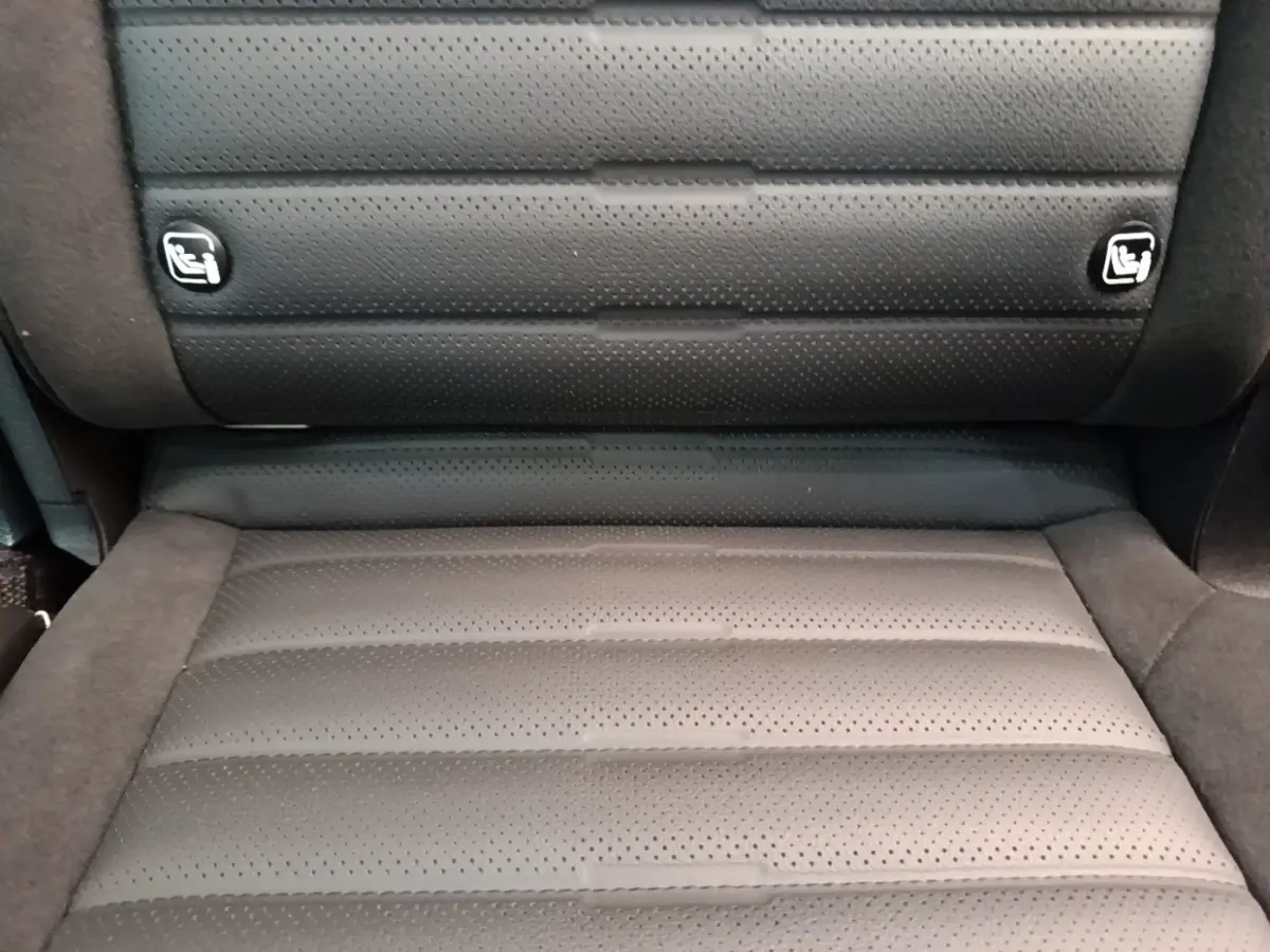Gros plan sur l’assise arrière en cuir perforé gris foncé du Kia Sportage 2022, avec ancrages Isofix visibles.