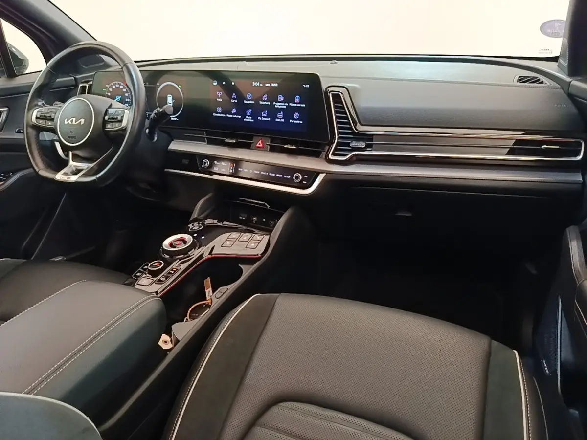Intérieur avant du Kia Sportage 2022 gris clair, tableau de bord moderne avec écran tactile large et volant multifonctions.