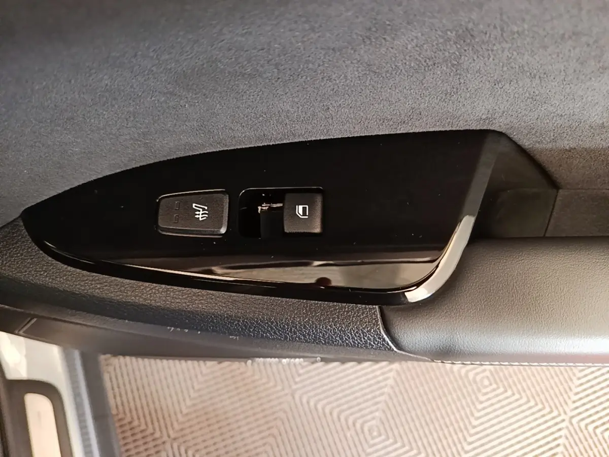 Gros plan sur les commandes de verrouillage et chauffage du siège côté conducteur d’un KIA Sportage gris clair 2022.
