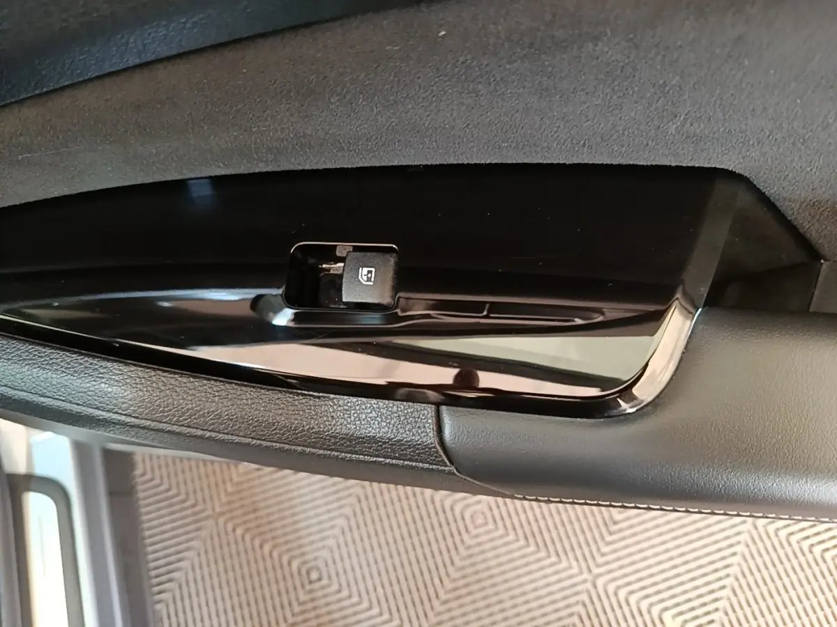 Gros plan sur le bouton de commande de lève-vitre côté conducteur du Kia Sportage gris clair 2022.