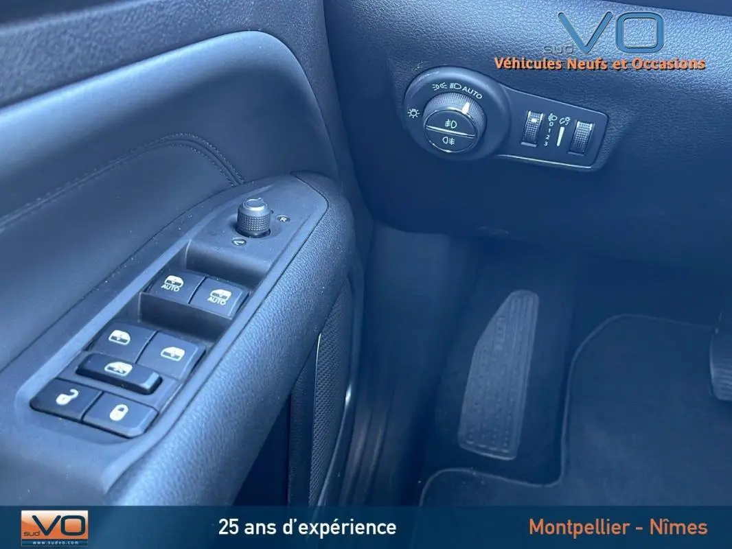 Vue rapprochée du panneau de commandes côté gauche du Jeep Compass blanc 2024 avec réglages vitres et phares automatiques.