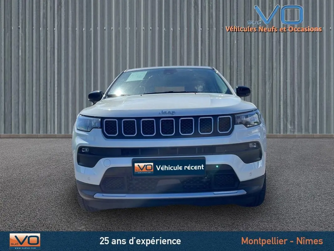 Vue frontale d'un Jeep Compass blanc 2024 avec calandre distinctive à sept fentes et phares LED intégrés.