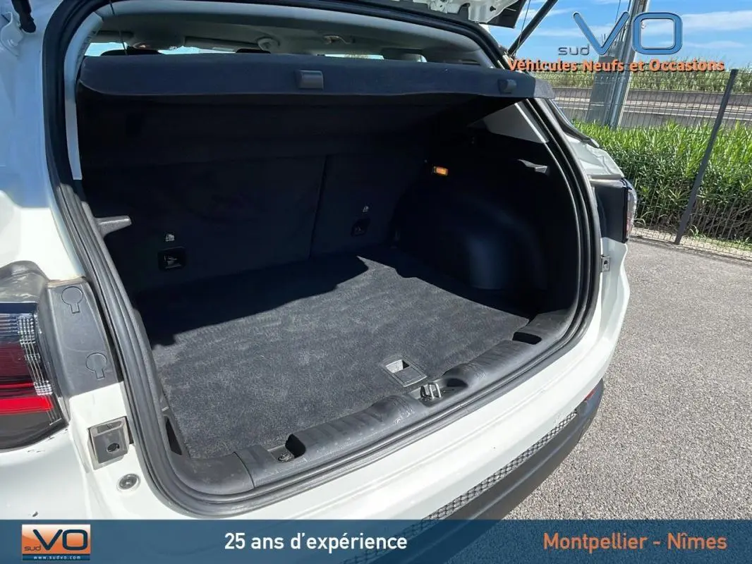 Coffre ouvert du Jeep Compass blanc 2024 vu de l'arrière droit, montrant un espace de chargement propre et spacieux.