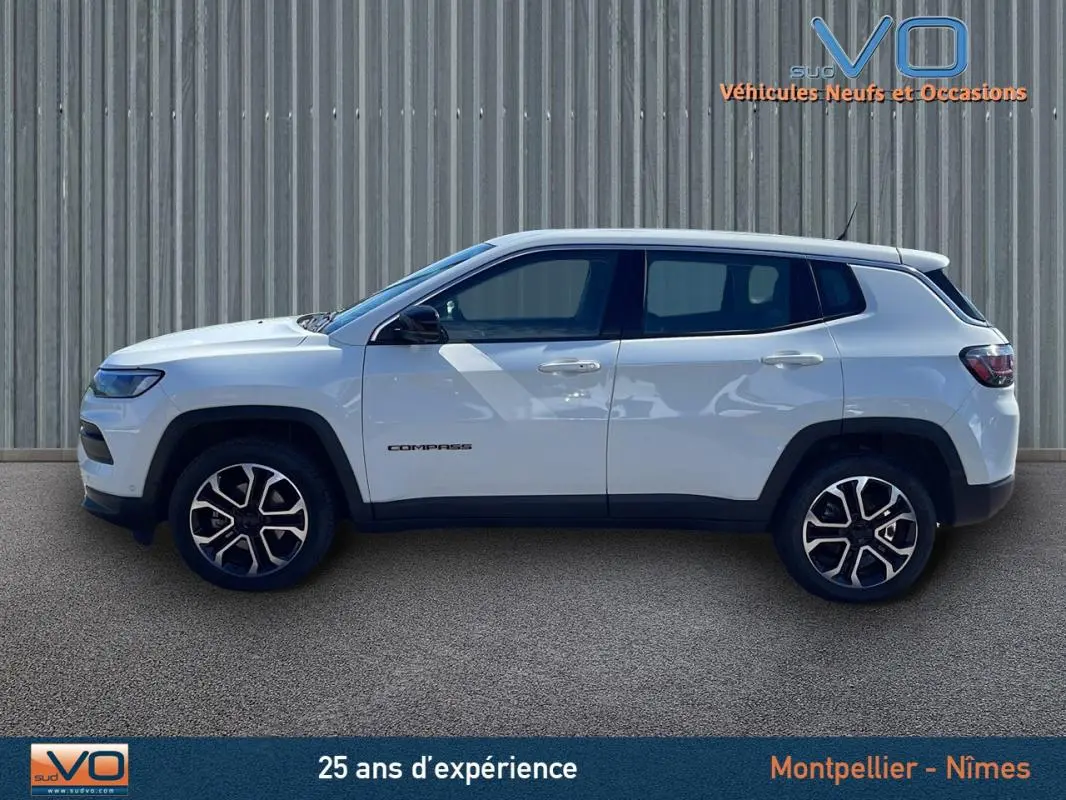 Profil côté gauche du Jeep Compass blanc 2024 avec jantes alliage 18 pouces et logo visible sur la porte.