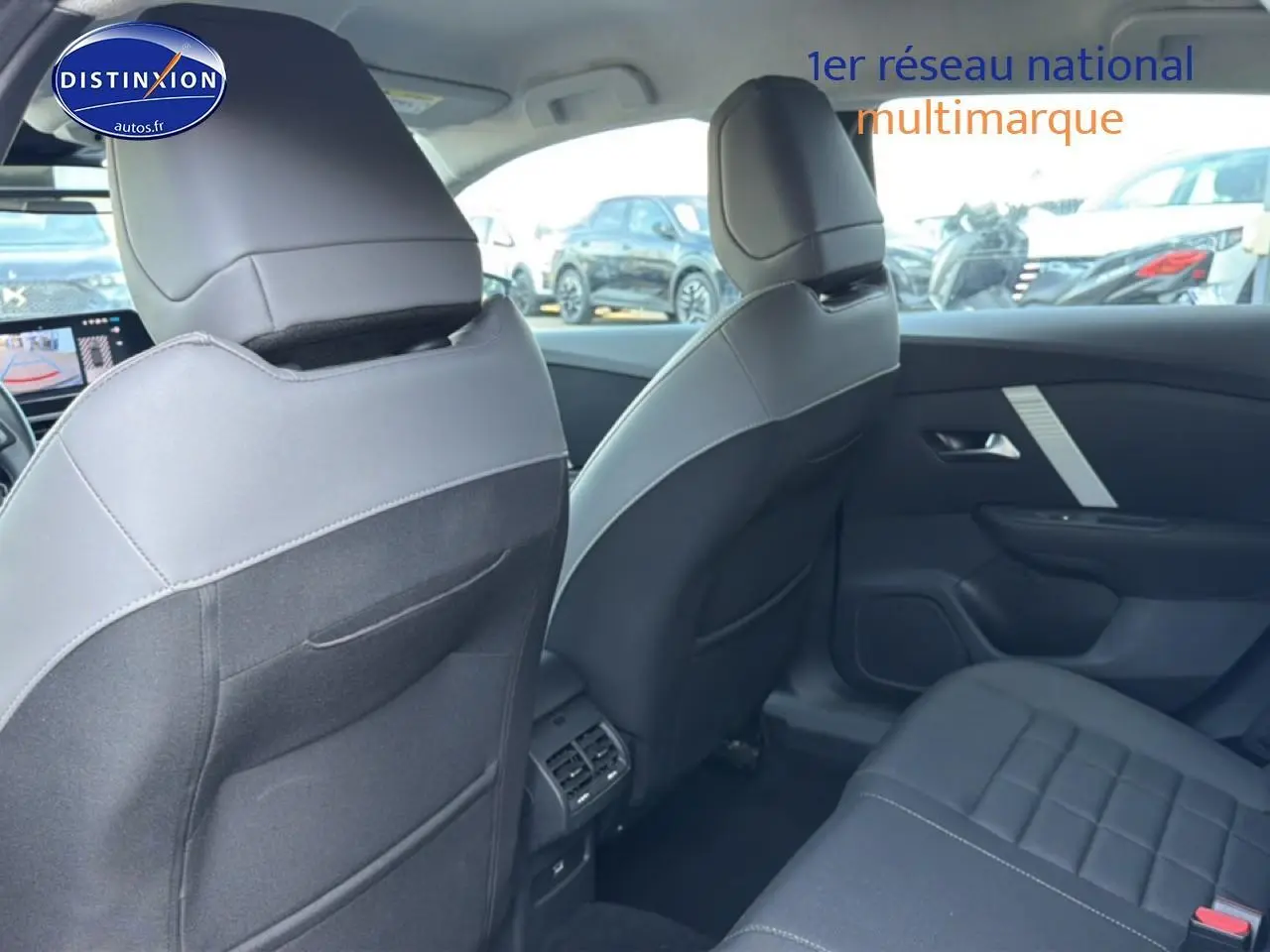 Vue intérieure arrière de la Citroën C4 électrique 2025 gris foncé, montrant les sièges et la console centrale.