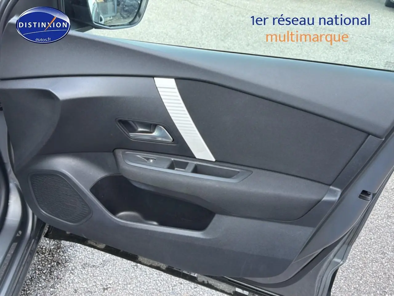 Vue intérieure de la porte avant gauche gris foncé de la Citroën C4 électrique avec haut-parleur intégré et poignée métallique.