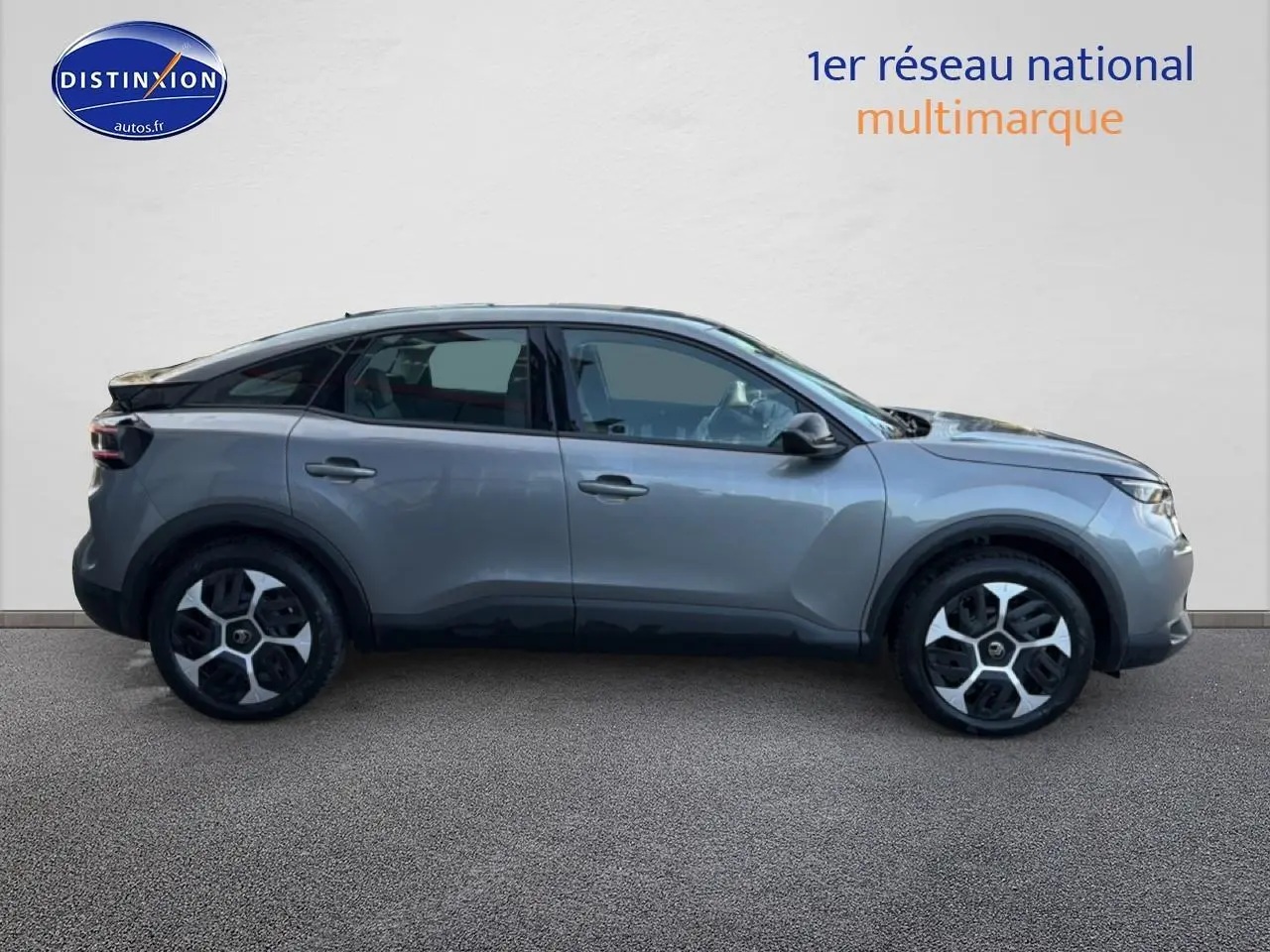 Vue latérale droite d'une Citroën C4 électrique 2025 gris foncé avec jantes distinctives et lignes modernes.