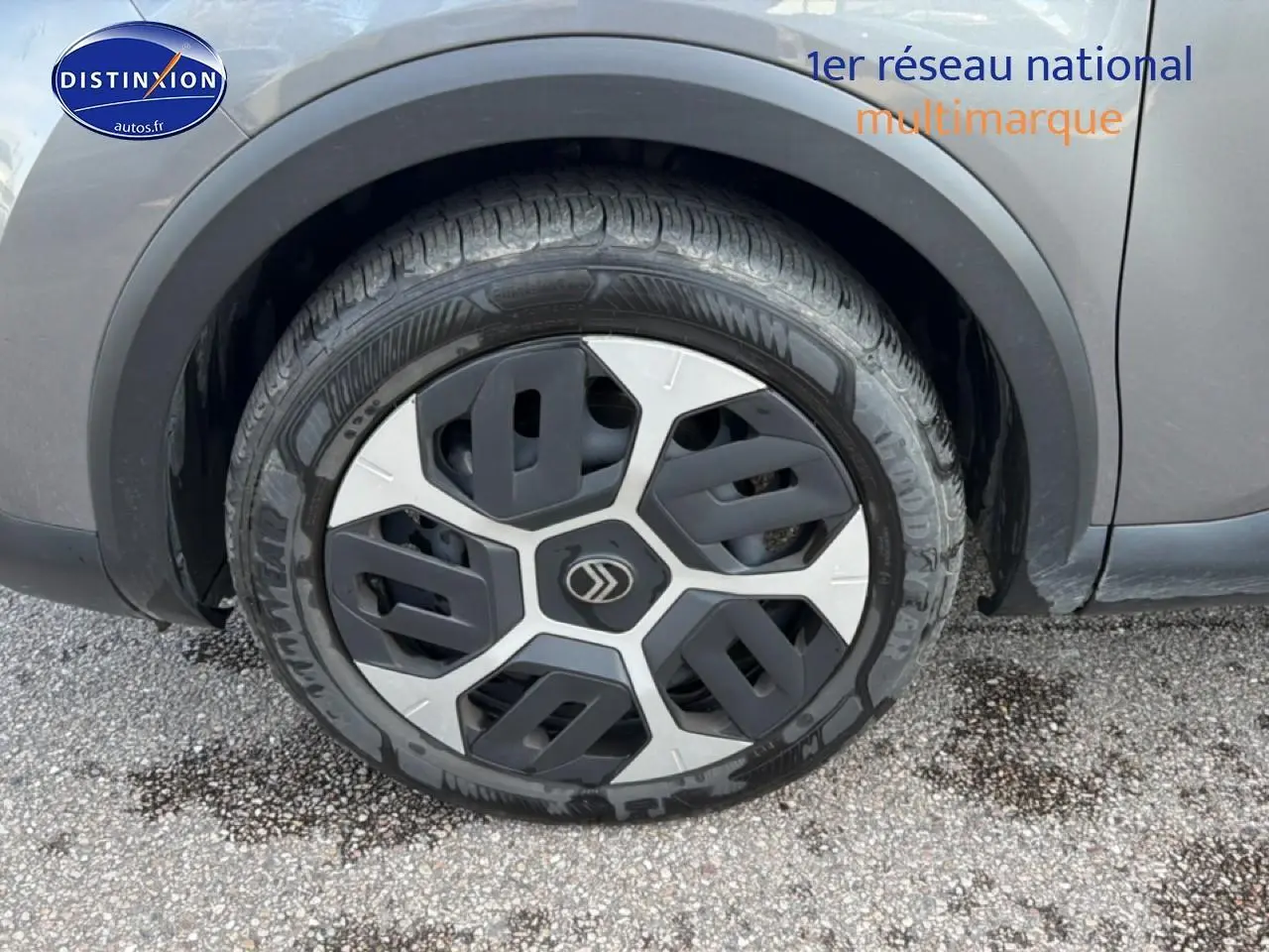 Gros plan sur la roue avant droite d'une Citroën C4 électrique 2025 gris foncé avec jante au design moderne.