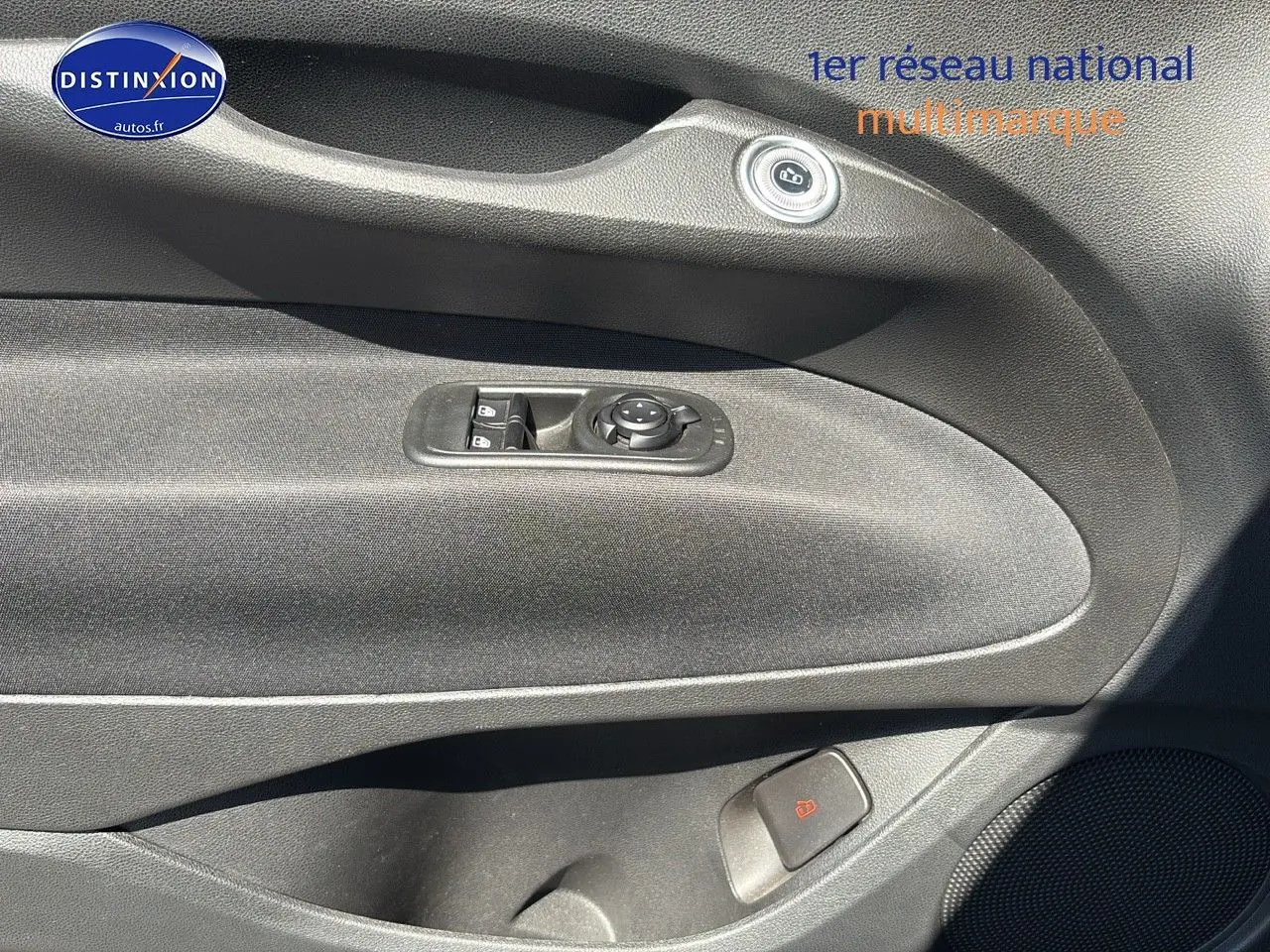 Détail de la porte avant gauche noire de la Fiat 500 électrique blanche 2024 avec commandes de vitres et verrouillage.