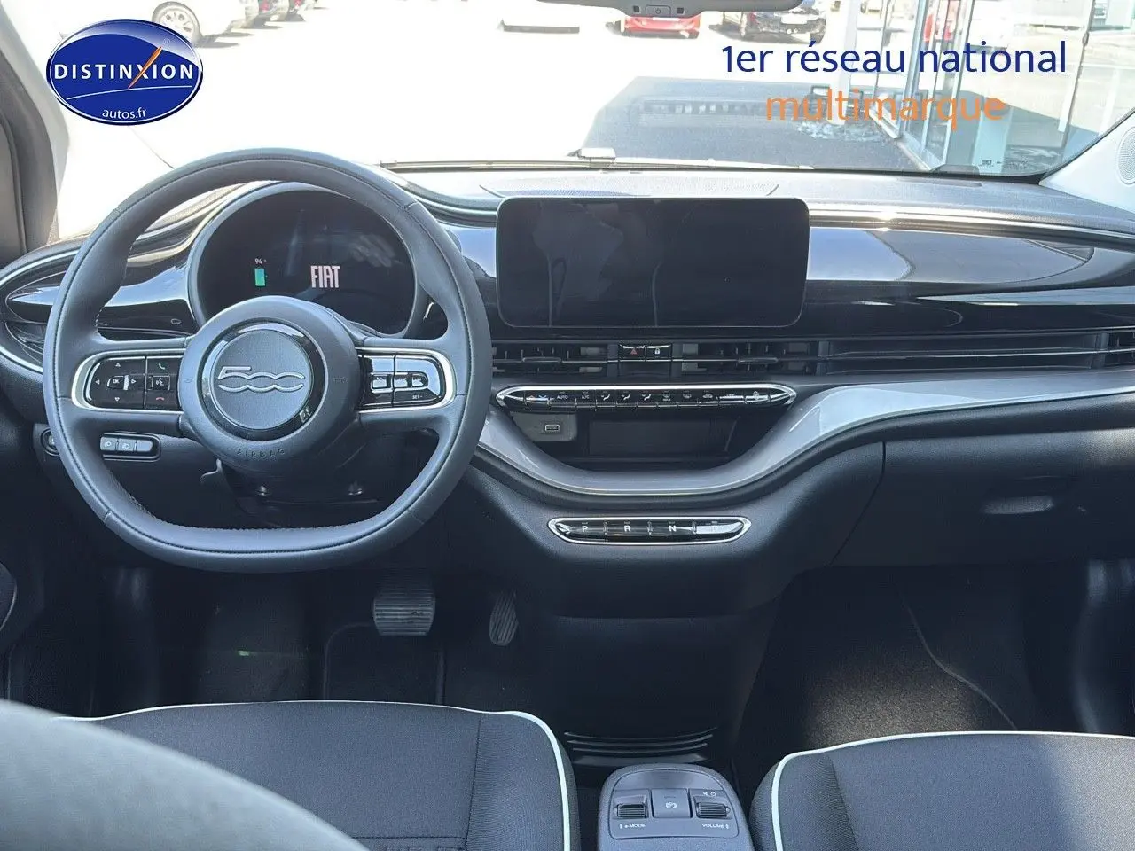 Vue intérieure avant du tableau de bord noir et volant multifonction de la Fiat 500 électrique blanche 2024.