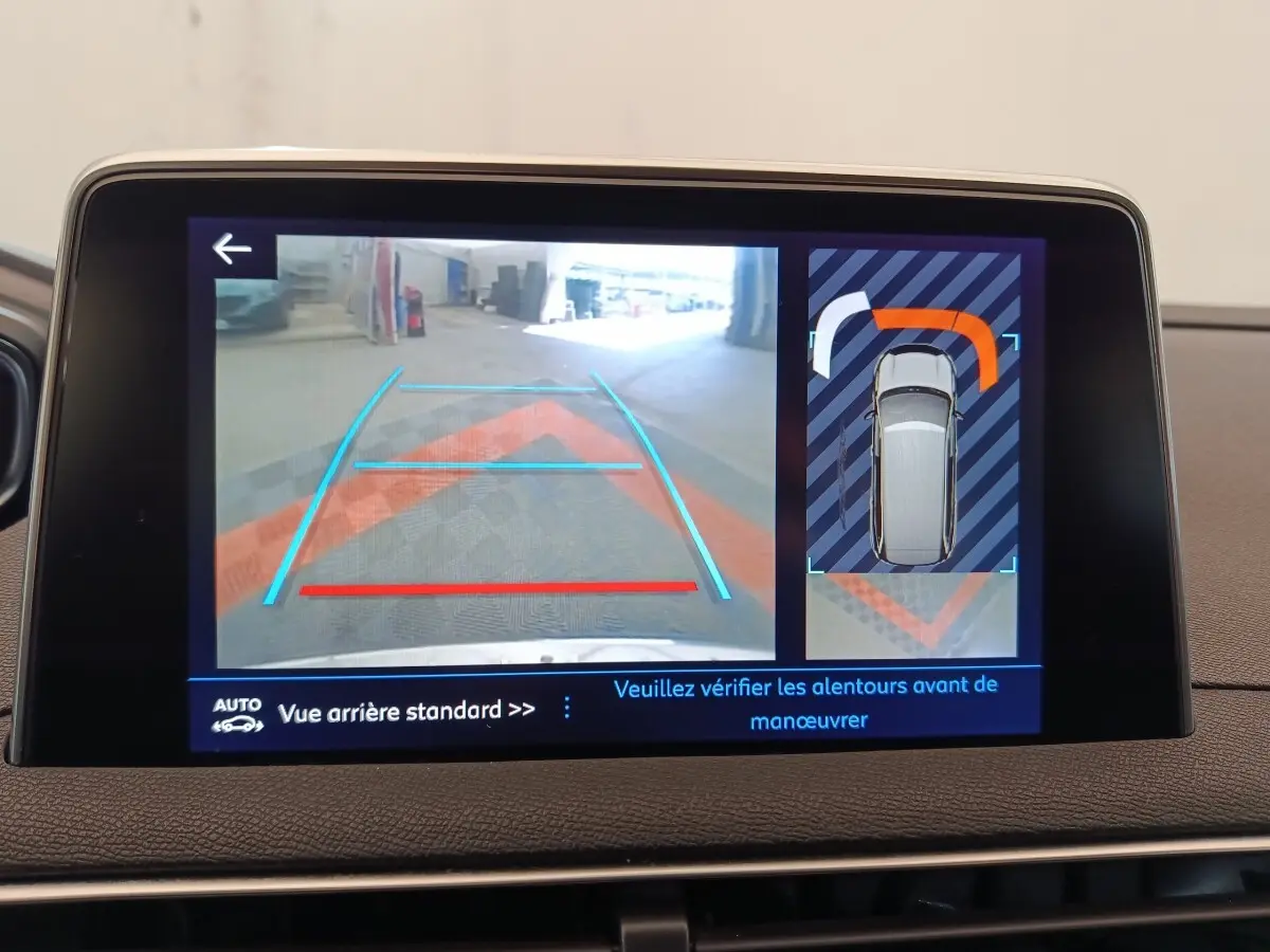 Écran tactile affichant la caméra de recul et l’aide au stationnement du Peugeot 5008 gris clair, vue intérieure.